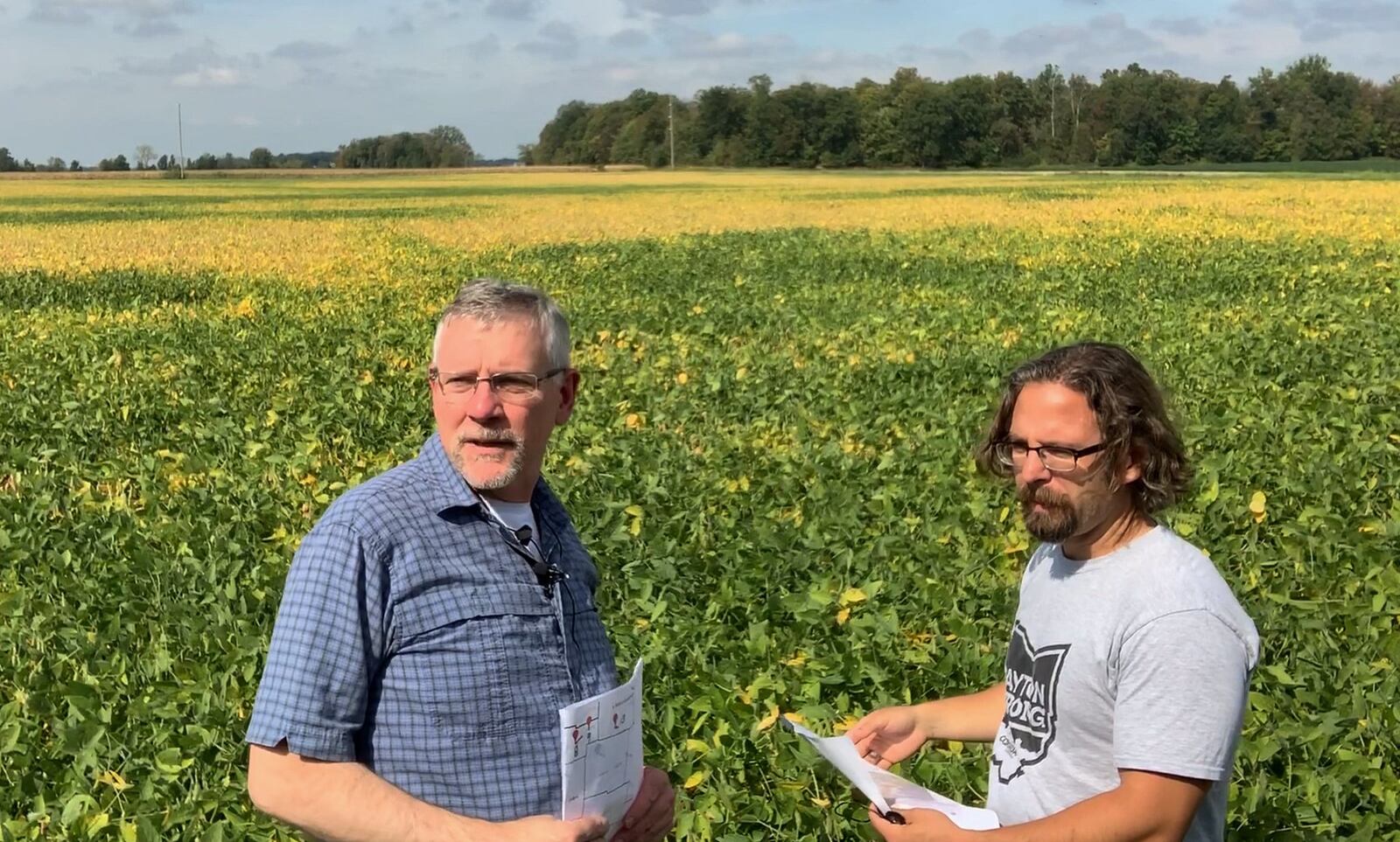 Dayton Daily News reporters Chris Stewart, left, and Josh Sweigart examine the Perry Twp. field in western where an EF4 tornado formed on Memorial Day and began its destructive rampage across Montgomery County. CHRIS STEWART / STAFF