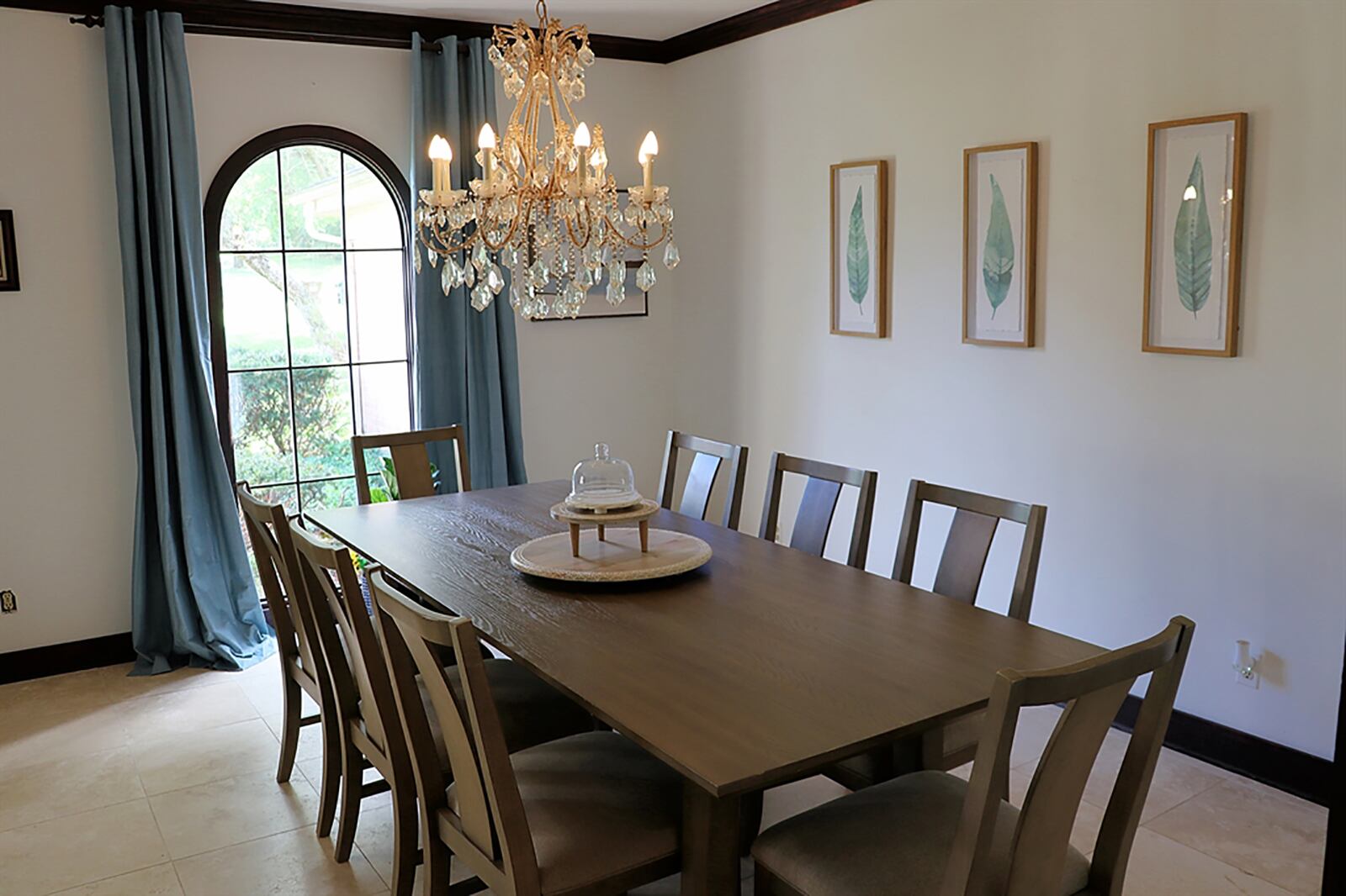 The formal dining room is off the living room and has an arched window and similar crown molding and trim. CONTRIBUTED PHOTO BY KATHY TYLER