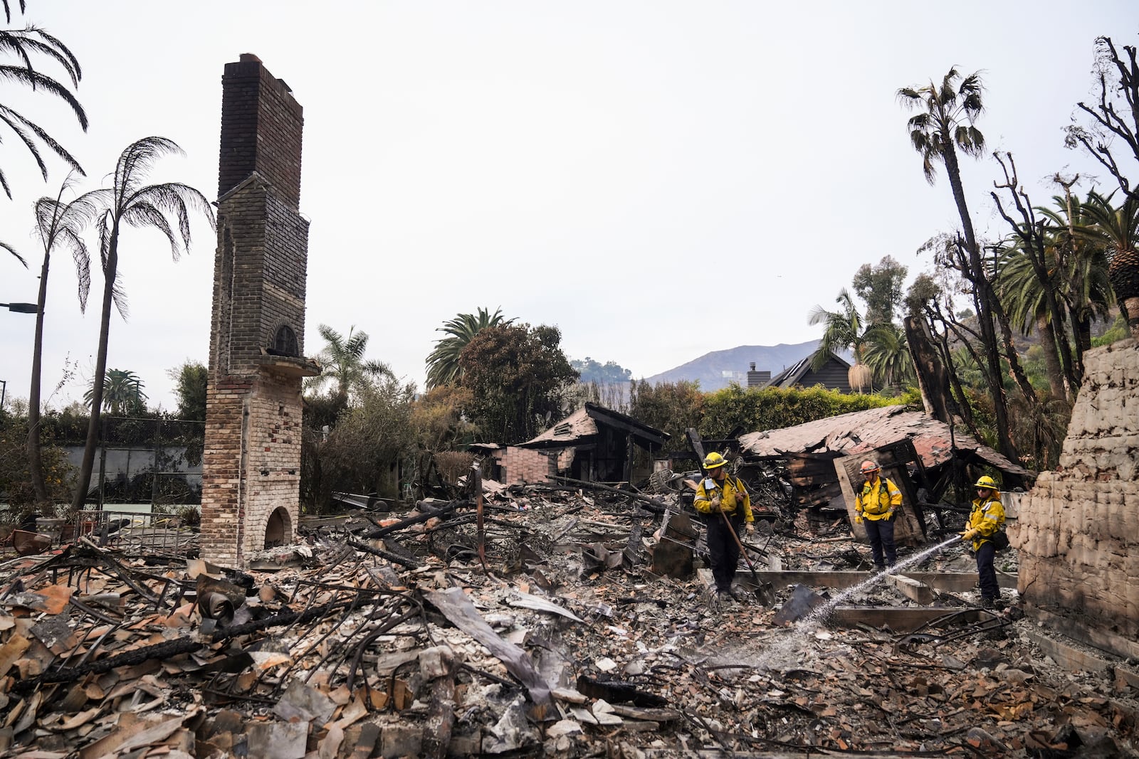 Firefighters work at a home devastated by the Franklin Fire in Malibu, Calif., Wednesday, Dec. 11, 2024. (AP Photo/Jae C. Hong)