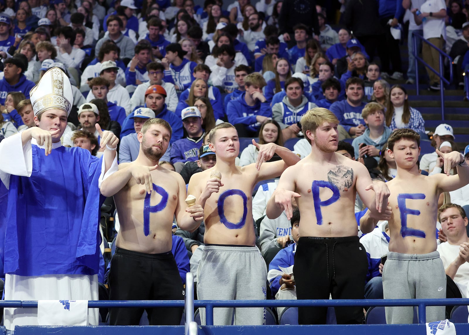 Kentucky students give L's down before an NCAA college basketball game against Louisville in Lexington, Ky., Saturday, Dec. 14, 2024. The Pope referred to is Kentucky head coach Mark Pope. (AP Photo/James Crisp)