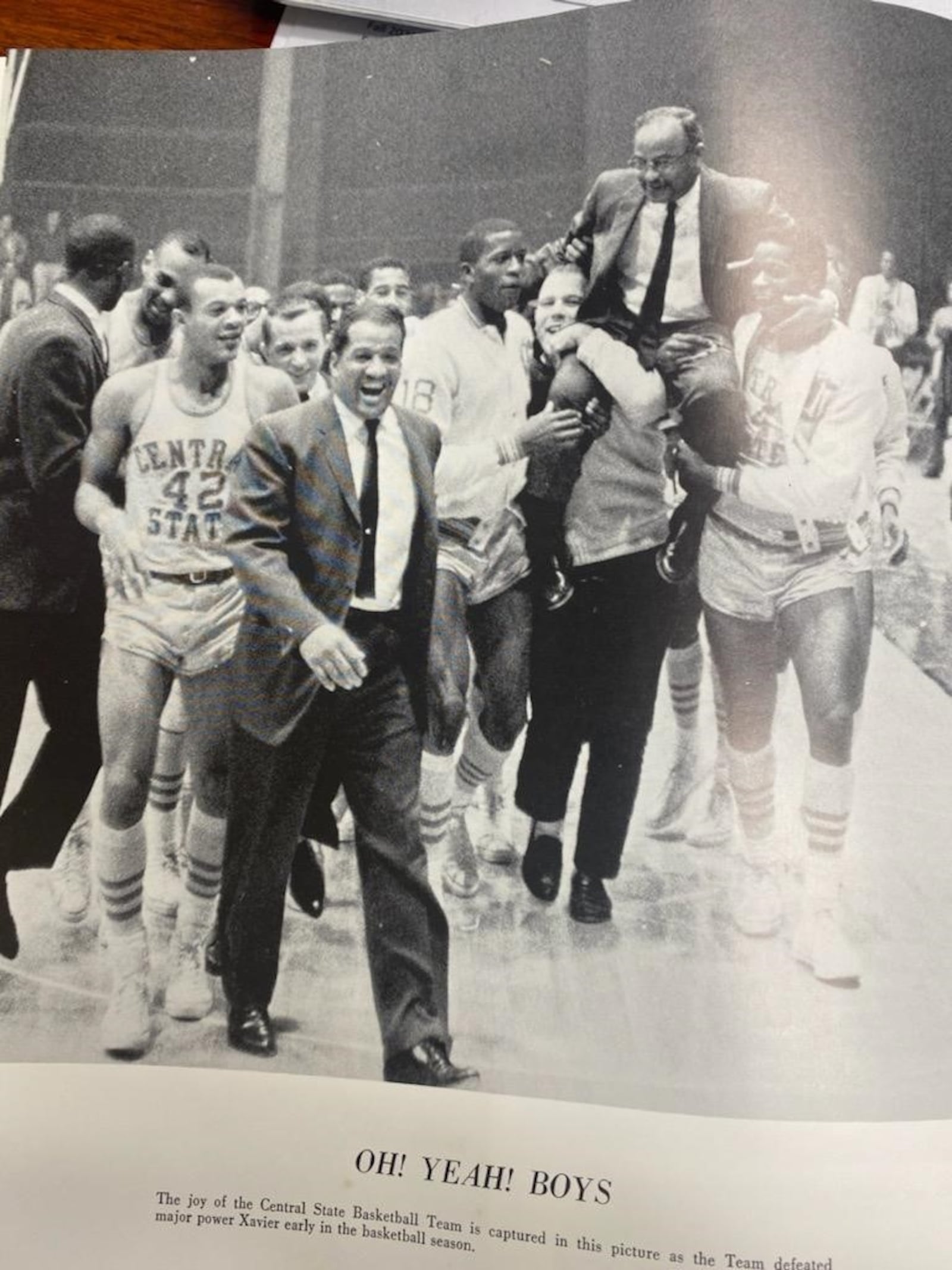 Ted Day (No. 42 , left) comes off the court after Central State defeated Oklahoma Baptist, 85-51, to win the NAIA national title at Municipal Auditorium in Kansas City in March of 1965. The Marauders finished the season 30-0. Coach William Lucas is being carried on the shoulders of the jubilant CSU players and fans. CONTRIBUTED