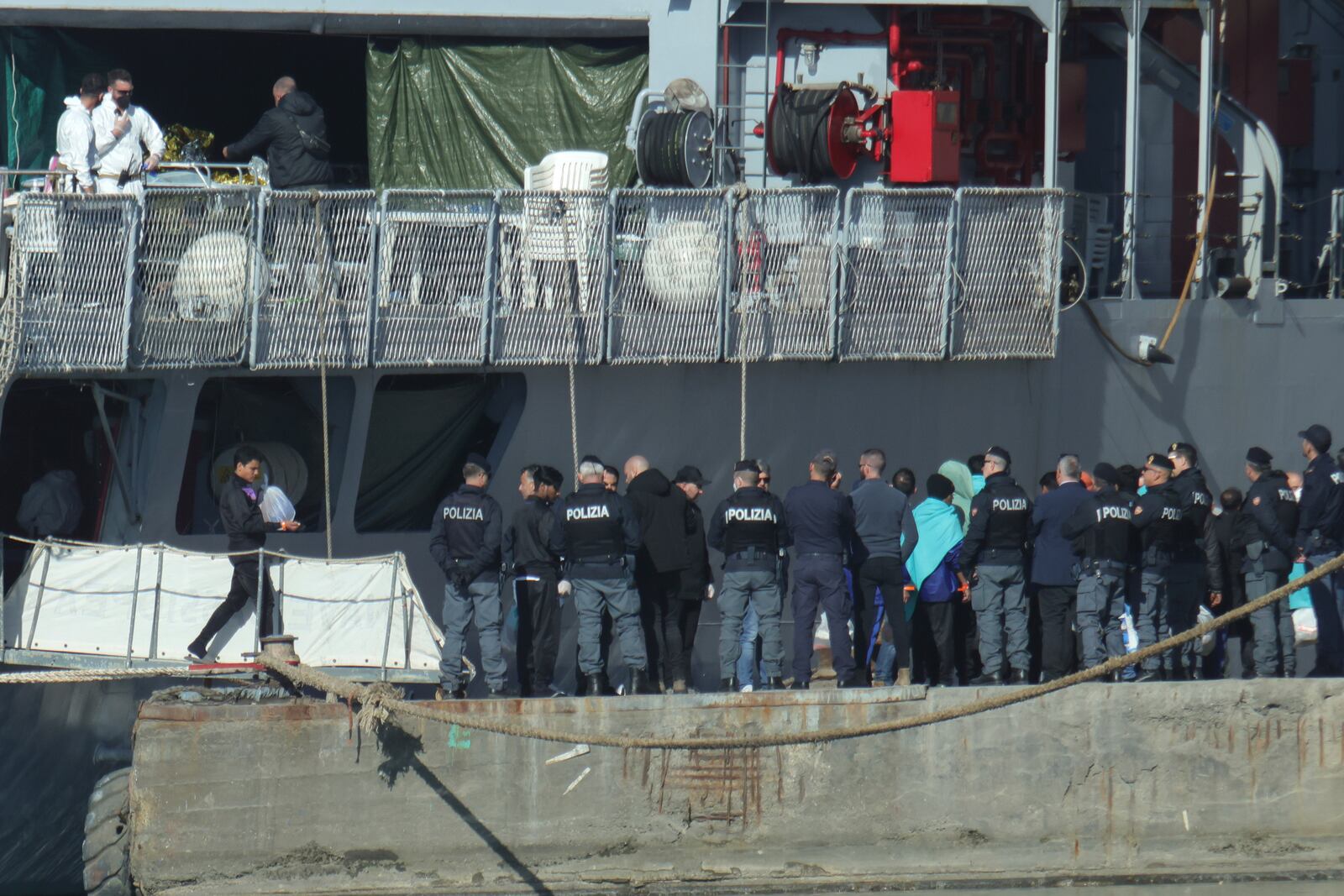 Migrants disembark an Italian Navy ship, as Italy sent 49 people to Albania for processing following earlier court rejections to Albania, in Shengjin, northwestern Albania, Tuesday, Jan. 28, 2025. (AP Photo/Vlasov Sulaj)