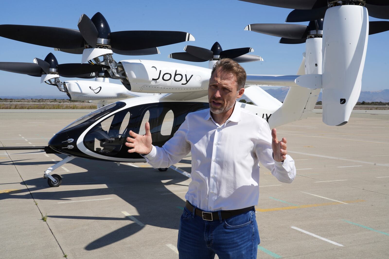 JoeBen Bevirt, CEO of Joby Aviation, stands next to an "electric vertical take-off and landing" aircraft, also known as an eVTOL, in Marina, Calif. on Monday, Oct. 7, 2024. (AP Photo/Terry Chea)