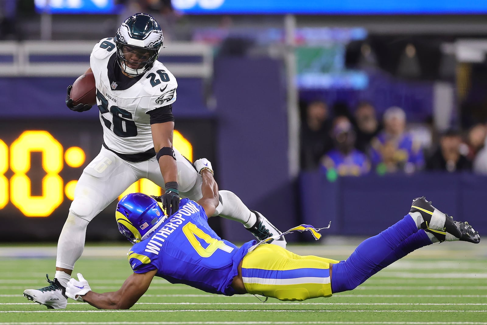 Philadelphia Eagles running back Saquon Barkley (26) runs against Los Angeles Rams cornerback Ahkello Witherspoon (4) during the second half of an NFL football game in Inglewood, Calif., Sunday, Nov. 24, 2024. (AP Photo/Ryan Sun)