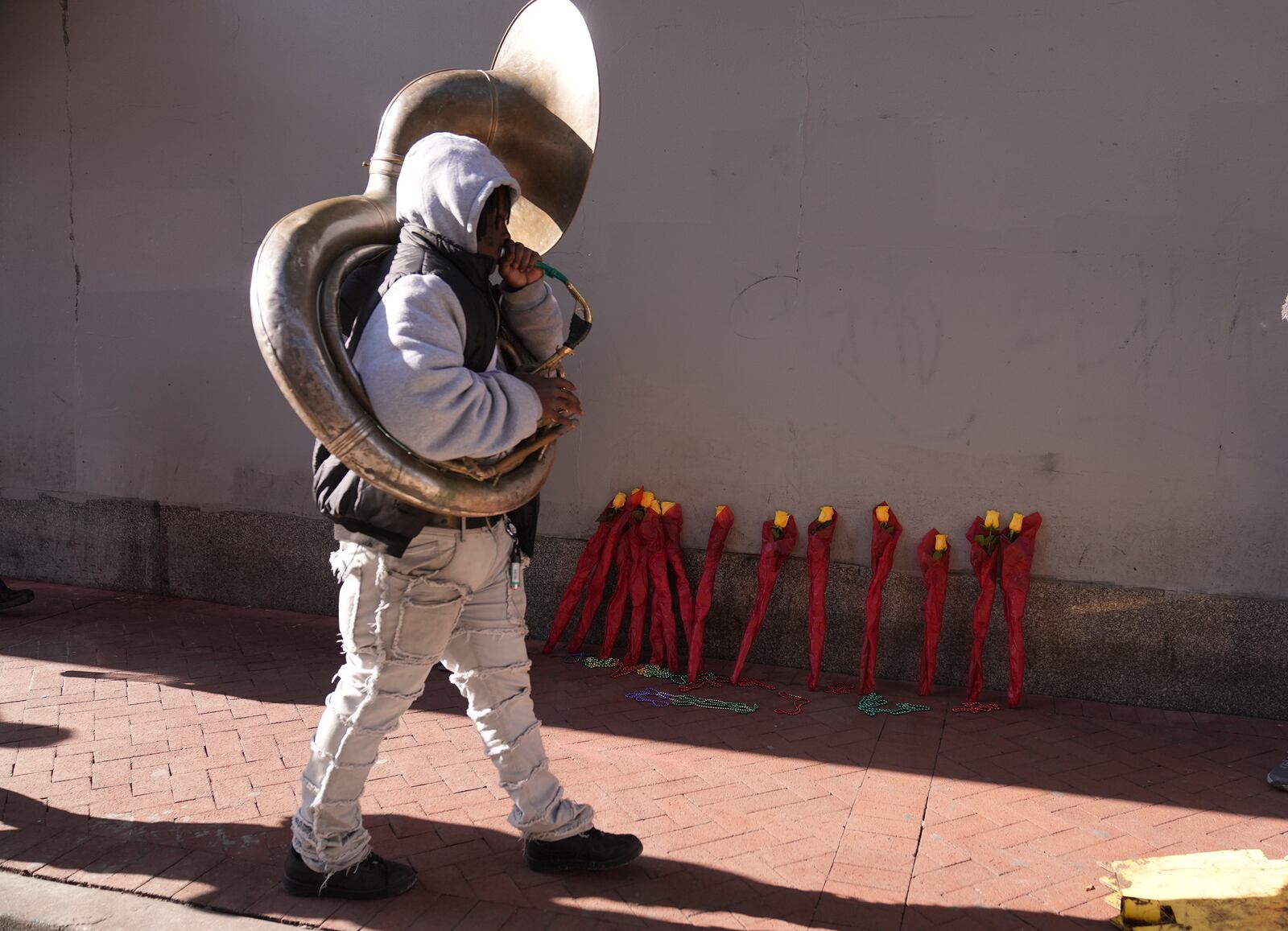 Tyrone Johnson walks past a flower memorial on Canal and Bourbon Street, Thursday, Jan. 2, 2025 in New Orleans. (AP Photo/George Walker IV)