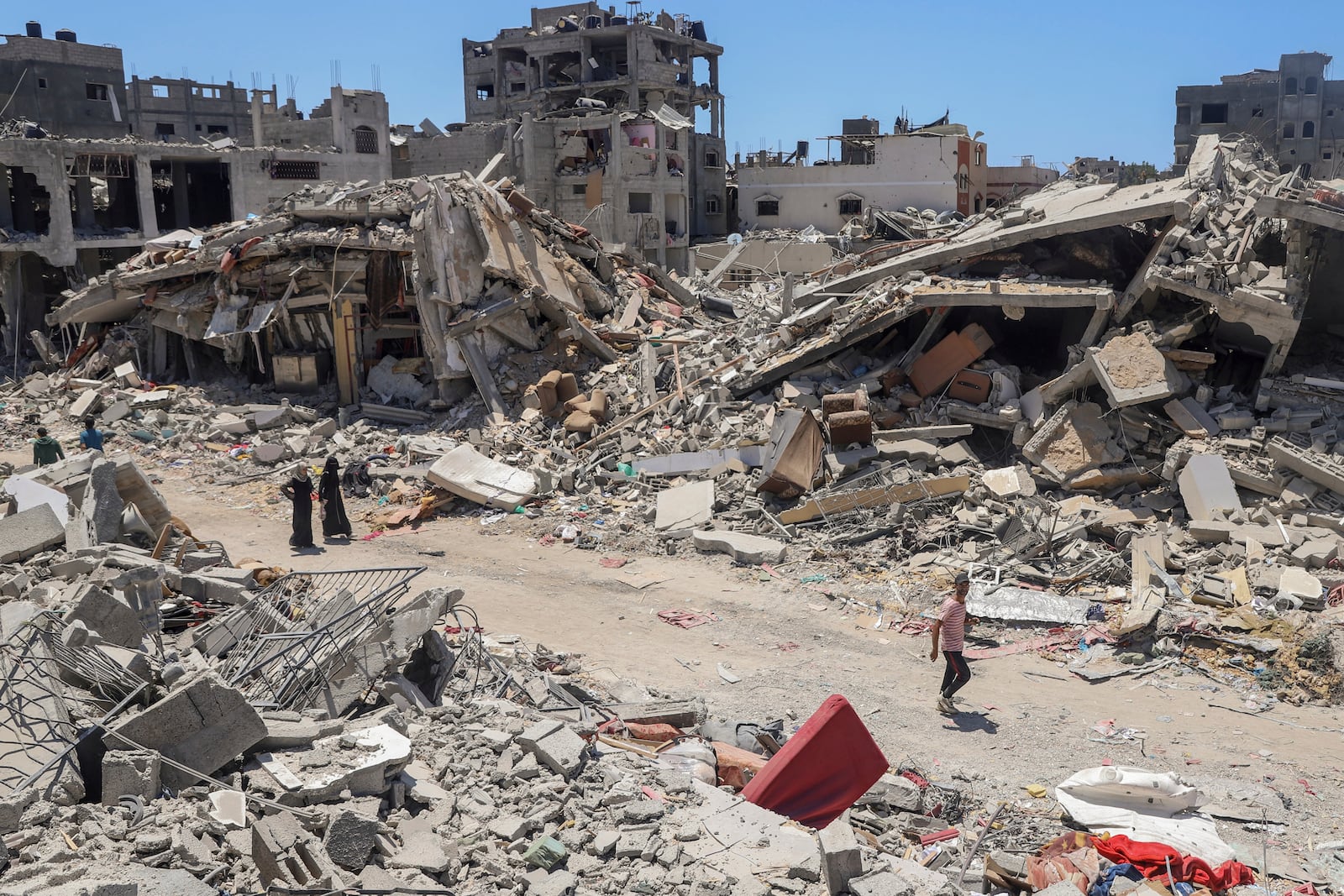 FILE - Palestinians walk through the destruction in the wake of an Israeli air and ground offensive in Jebaliya, northern Gaza Strip, on May 30, 2024. (AP Photo/Enas Rami, File)