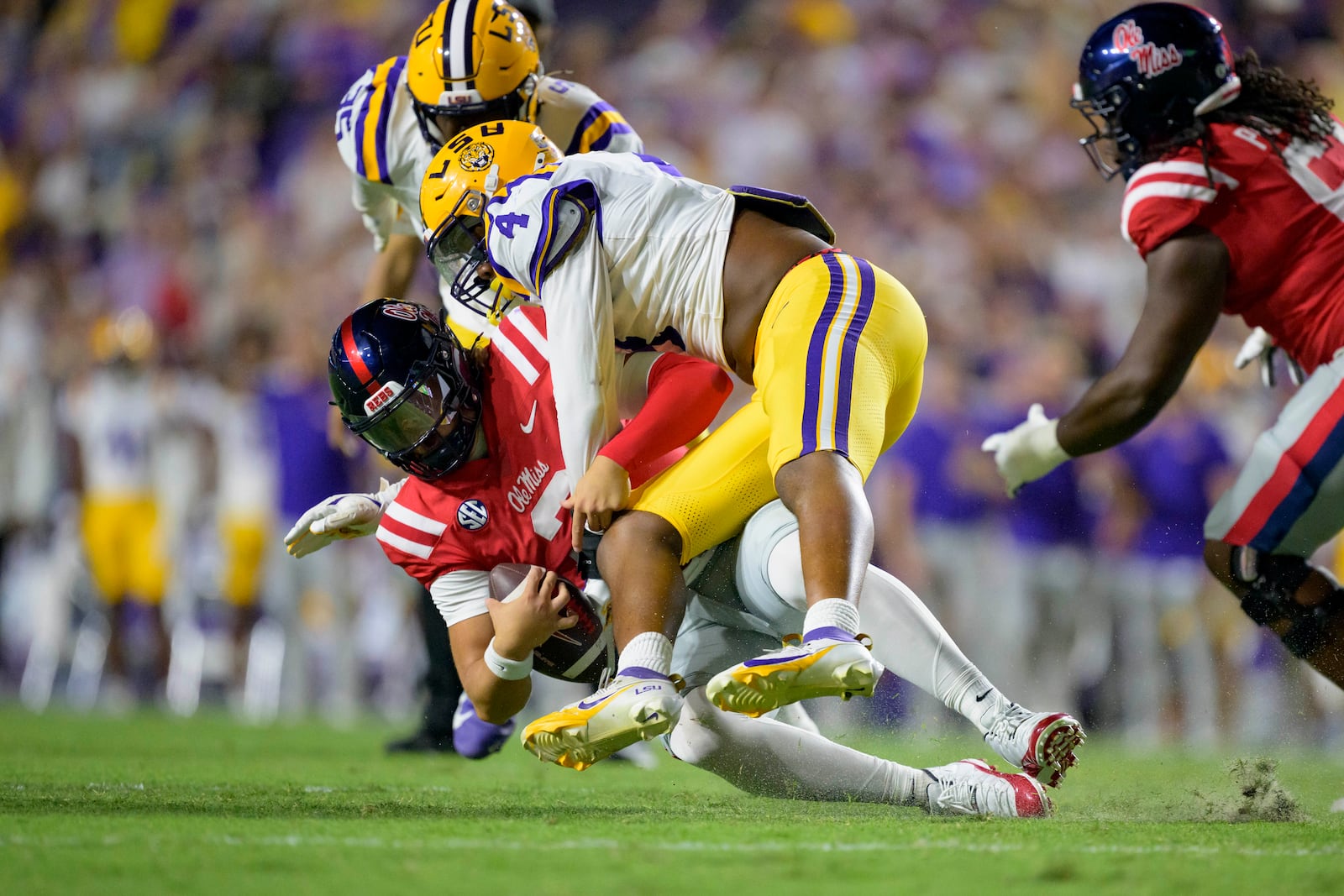 Mississippi quarterback Jaxson Dart (2) is sacked by LSU defensive end Bradyn Swinson (4) during the first half of an NCAA college football game in Baton Rouge, La., Saturday, Oct. 12, 2024. (AP Photo/Matthew Hinton)