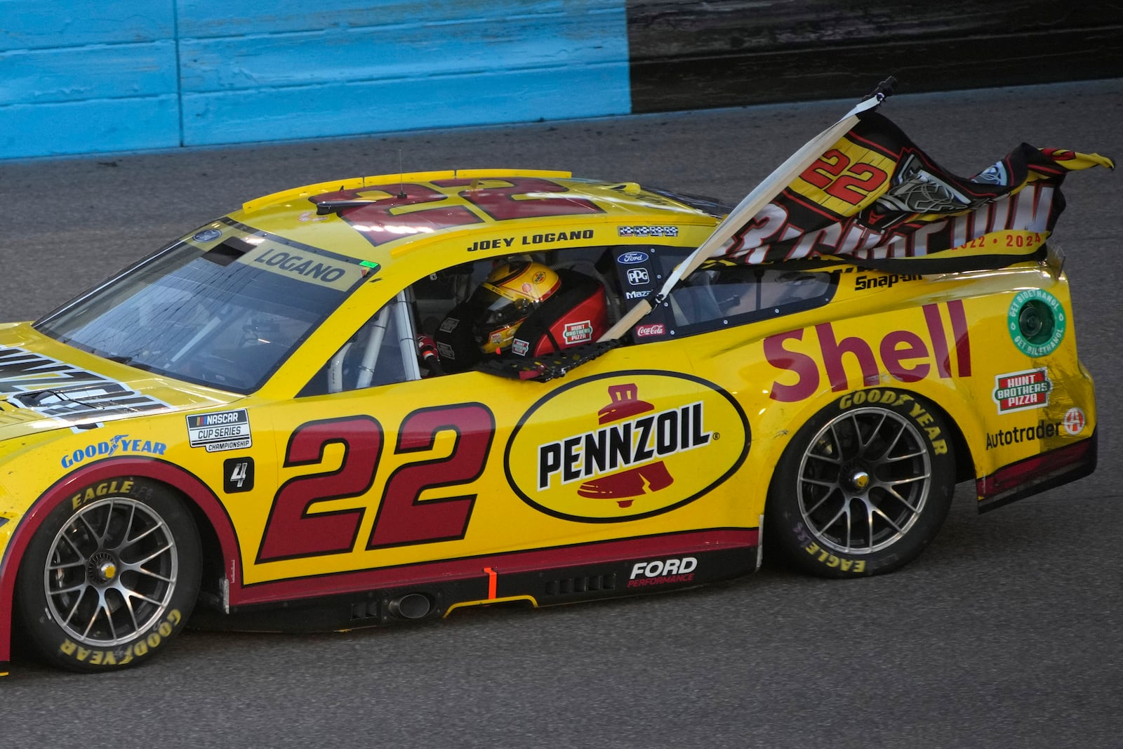 Joey Logano does a victory lap after winning a NASCAR Cup Series Championship auto race for the championship at Phoenix Raceway, Sunday, Nov. 10, 2024, in Avondale, Ariz. (AP Photo/John Locher)