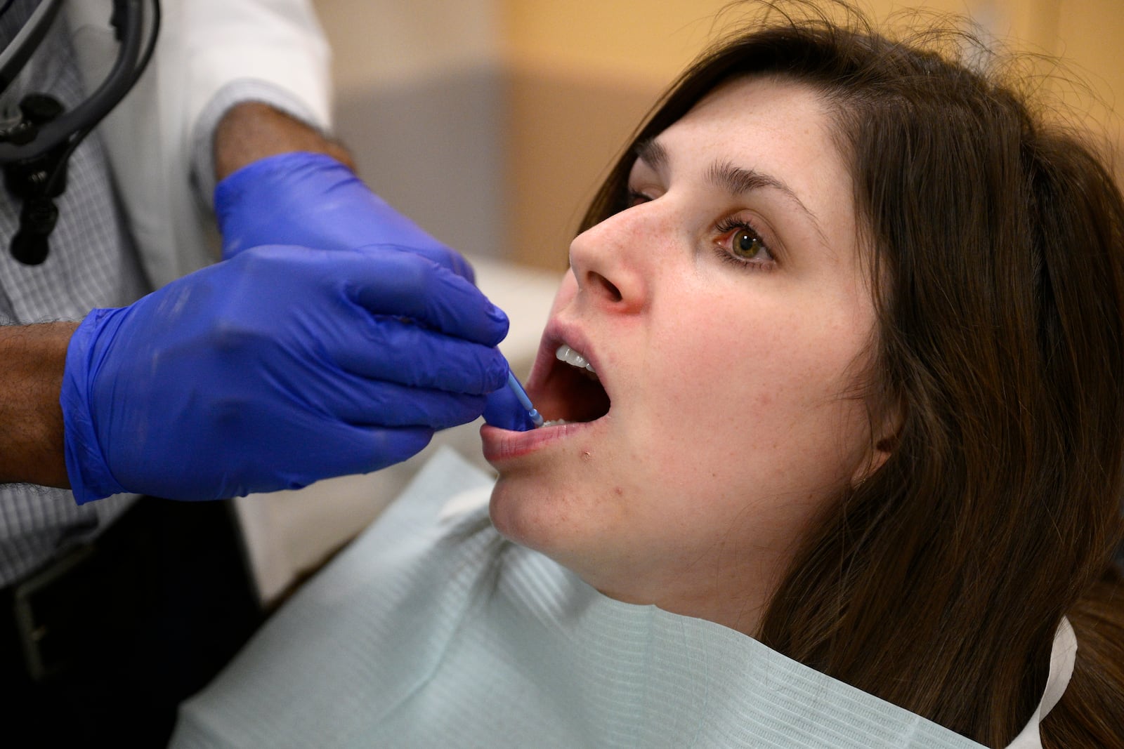 Alexander Daniel, DDS, left, demonstrates fluoride treatment on resident Cameron Onken, right, at the Johns Hopkins Outpatient Center, Friday, Feb. 28, 2025, in Baltimore. (AP Photo/Nick Wass)