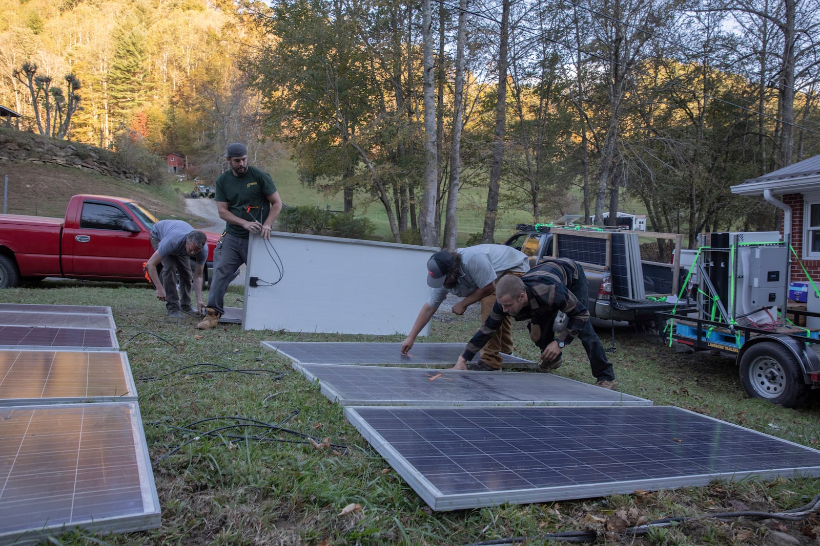 Hayden Wilson, left, Alexander Pellersels, second from left, Jonathan Bowen and Henry Kovacs, right, install a mobile power system at the Beans Creek Church of the Lord Jesus Christ in Bakersville, N.C. on Oct. 9, 2024. (AP Photo/Gabriela Aoun Angueria)