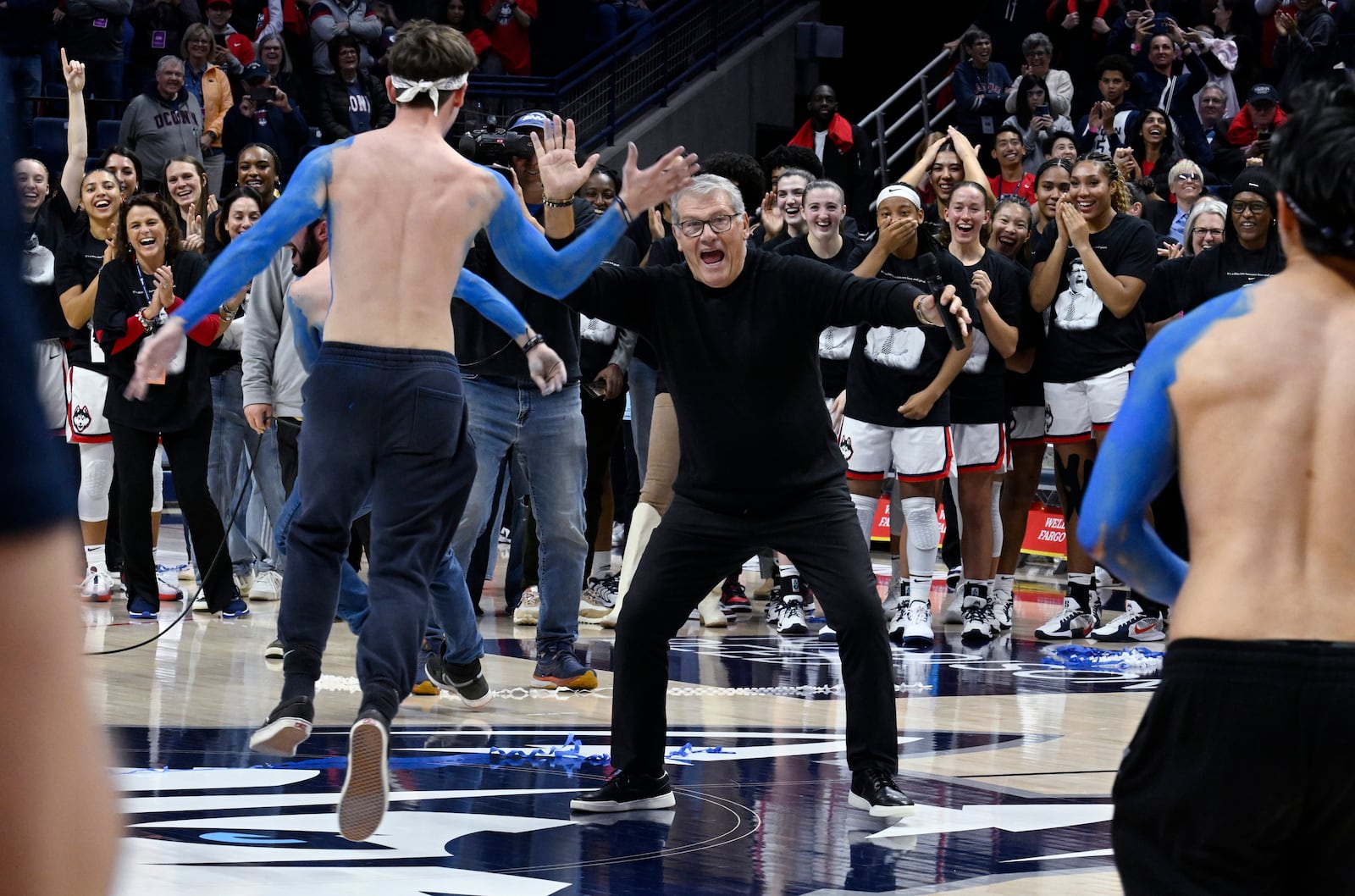 UConn head coach Geno Auriemma high fives students he called out onto the court during a post game ceremony celebrating the most wins in college basketball history, Wednesday, Nov. 20, 2024, in Storrs, Conn. (AP Photo/Jessica Hill)