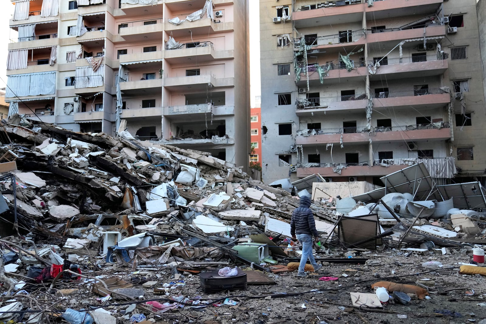 A man passes in front of destroyed buildings that were hit in an Israeli airstrike in Dahiyeh, in the southern suburb of Beirut, Lebanon, Thursday, Nov. 14, 2024. (AP Photo/Hussein Malla)