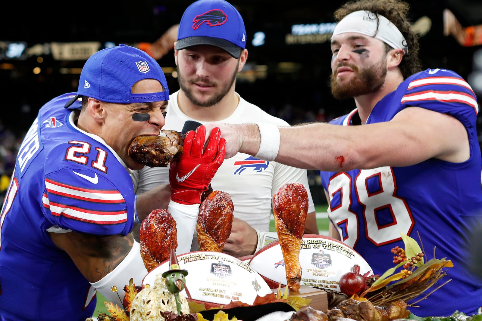 FIEL - Buffalo Bills wide receiver Stefon Diggs (14), safety Jordan Poyer (21), quarterback Josh Allen (17), and tight end Dawson Knox (88) eat a Thanksgiving turkey after an NFL football game against the New Orleans Saints, Thursday, Nov. 25, 2021, in New Orleans. (AP Photo/Tyler Kaufman, File)