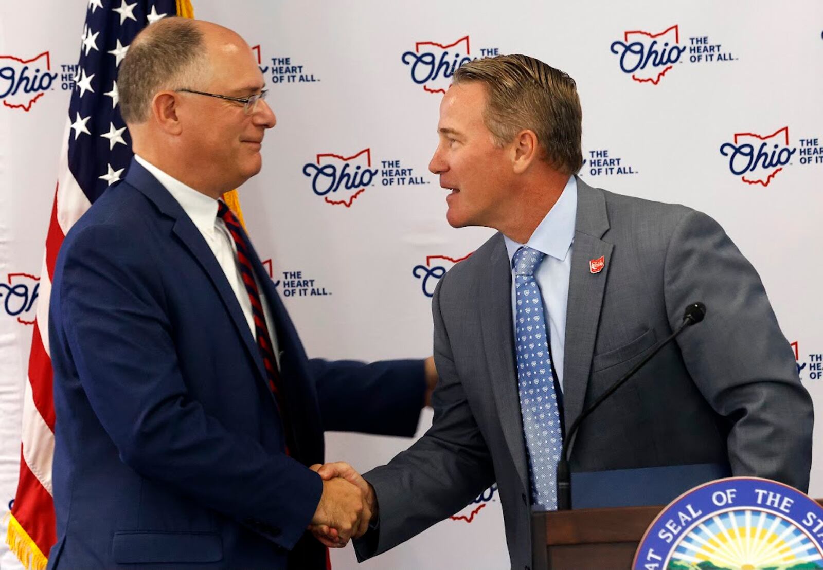 Eric Spina, left, the president of the University of Dayton, greets Jon Husted, Ohio's lieutenant governor and a UD graduate, Monday at UD. MARSHALL GORBY/STAFF