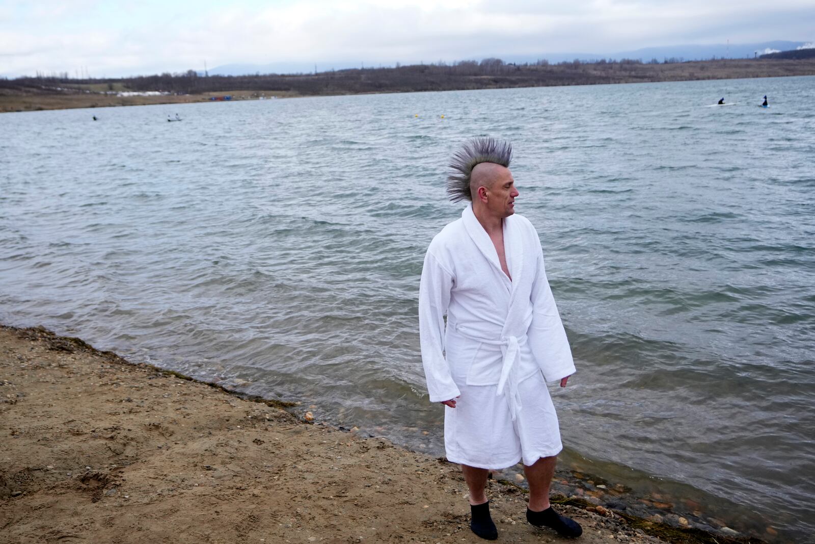 One of 2461 polar swimmers prepares to get in the water to set a world record for the largest polar bear dip at a lake in Most, Czech Republic, Saturday, March 1, 2025. (AP Photo/Petr David Josek)