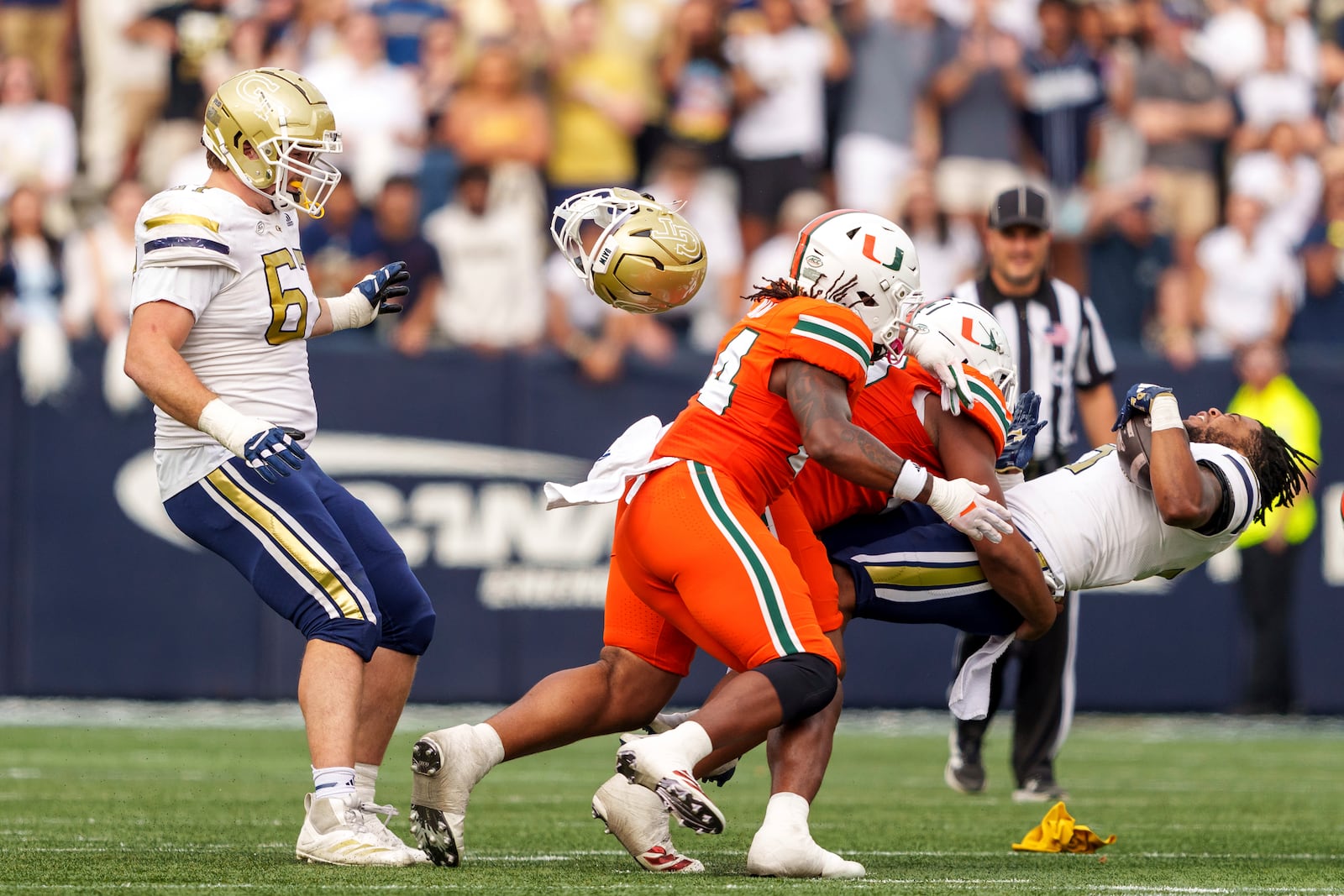 Georgia Tech running back Trey Cooley (3) loses his helmet while being tackled during the second half of an NCAA college football game against Miami, Saturday, Nov. 9, 2024, in Atlanta. (AP Photo/Jason Allen)