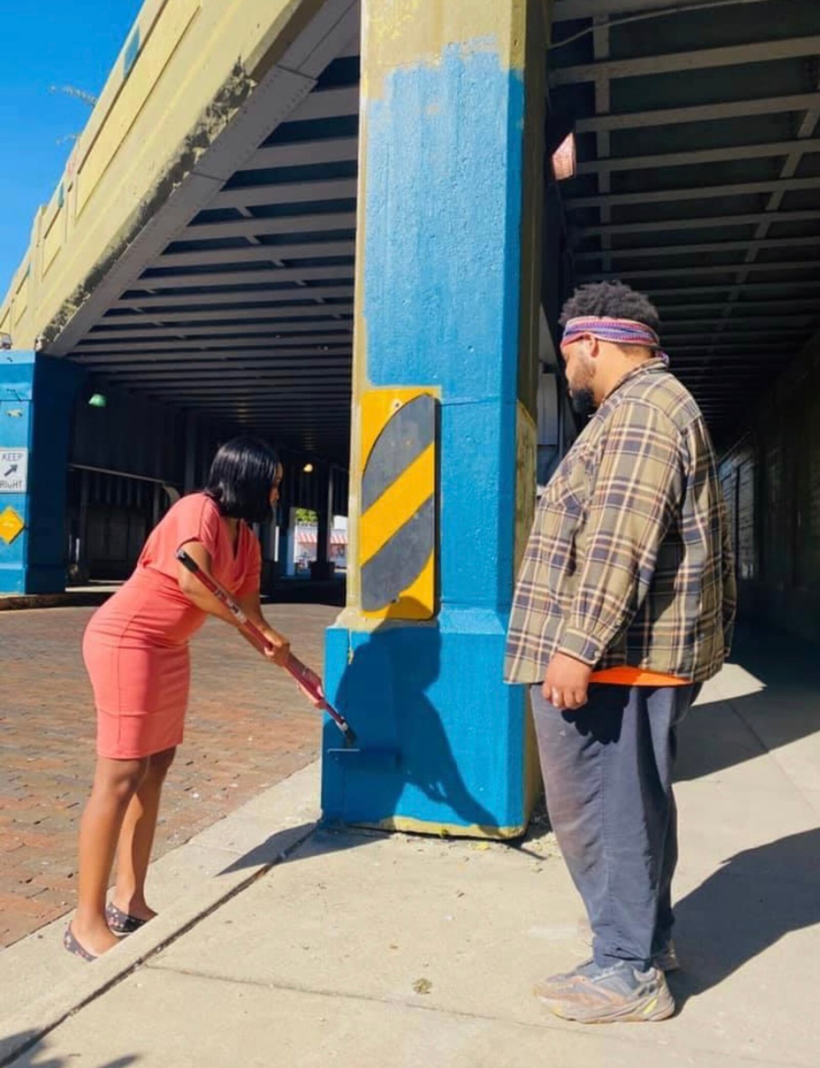 Lead mural artist, Dave Scott and a volunteer, get started on what will be the Oregon District bridge mural.