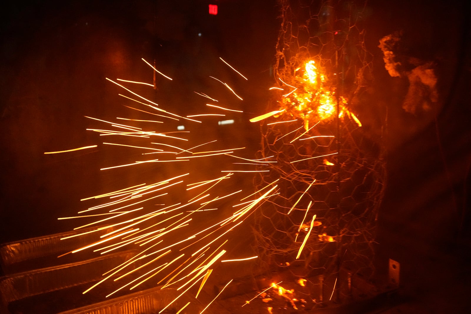 Sparks fly during a controlled burning of brush in a wind tunnel in lab at Worcester Polytechnic Institute, Wednesday, Jan. 15, 2025, in Worcester, Mass. (AP Photo/Robert F. Bukaty)