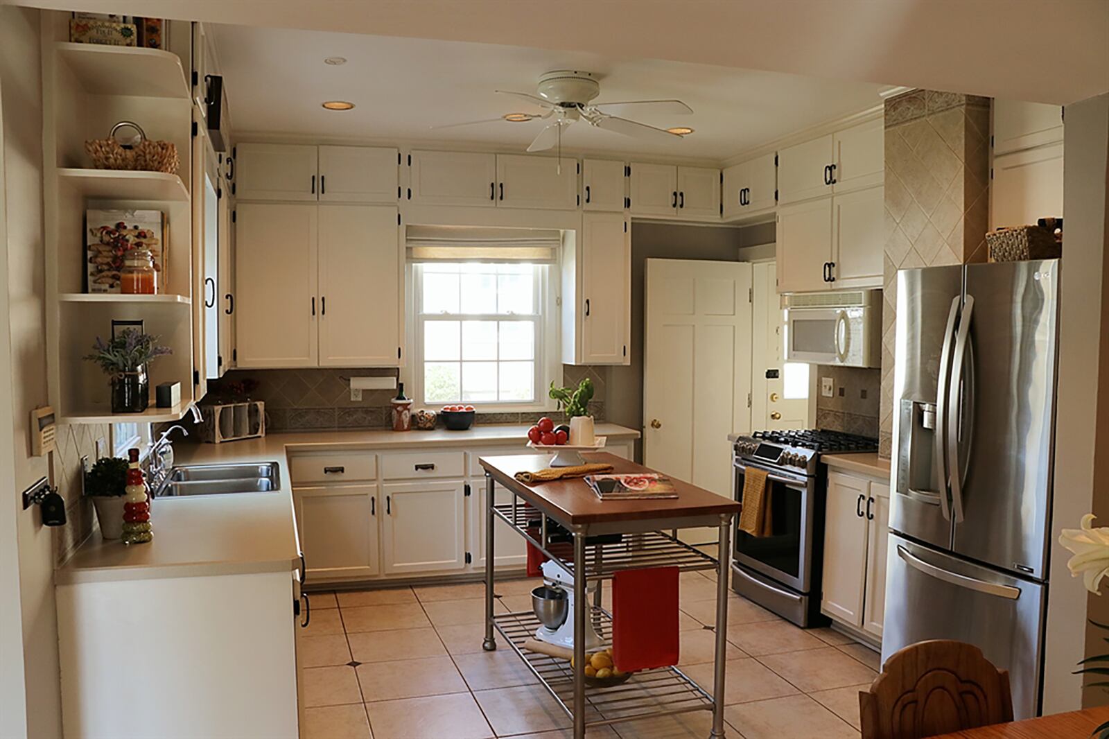 Ceramic-tile flooring flows into the eat-in kitchen, which is also accessible from the dining room and front foyer. White cabinetry fills three walls and extends to the ceiling. Ceramic-tile accents the wall space between the hanging cabinets and countertops. CONTRIBUTED PHOTO BY KATHY TYLER