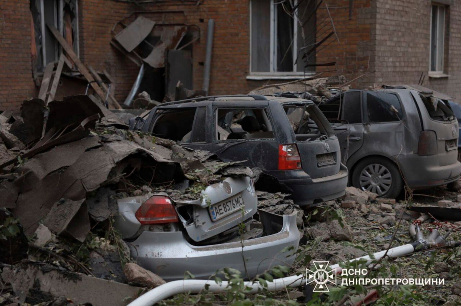 In this image provided by the Ukrainian Emergency Service on Monday, Nov. 11, 2024, damaged cars are seen in a yard of an apartments building destroyed by a Russian attack in Kryvyi Rih, Ukraine. (Ukrainian Emergency Service via AP)