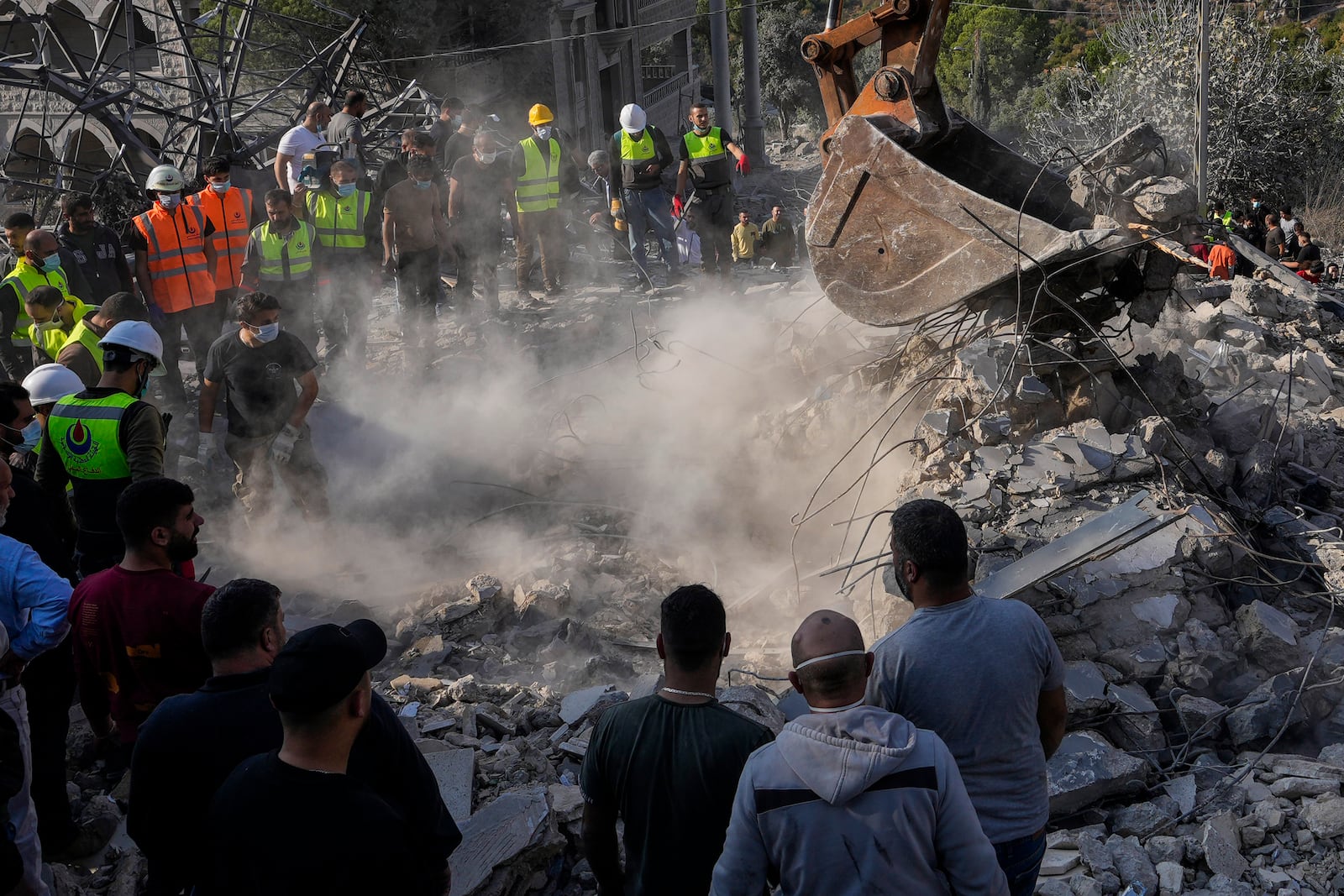 Rescue workers and people search for victims under the rubble of a destroyed house hit in an Israeli airstrike, in Aalmat village, northern Lebanon, Sunday, Nov. 10, 2024. (AP Photo/Hassan Ammar)