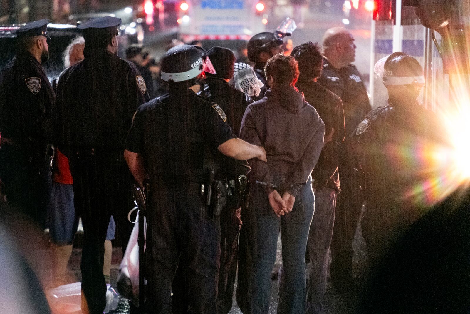 FILE - As light rain falls, New York City police officers take people into custody near the Columbia University campus in New York, Tuesday, April 30, 2024, after a building taken over by pro-Palestinian protesters earlier in the day was cleared, along with a tent encampment. (AP Photo/Craig Ruttle, File)