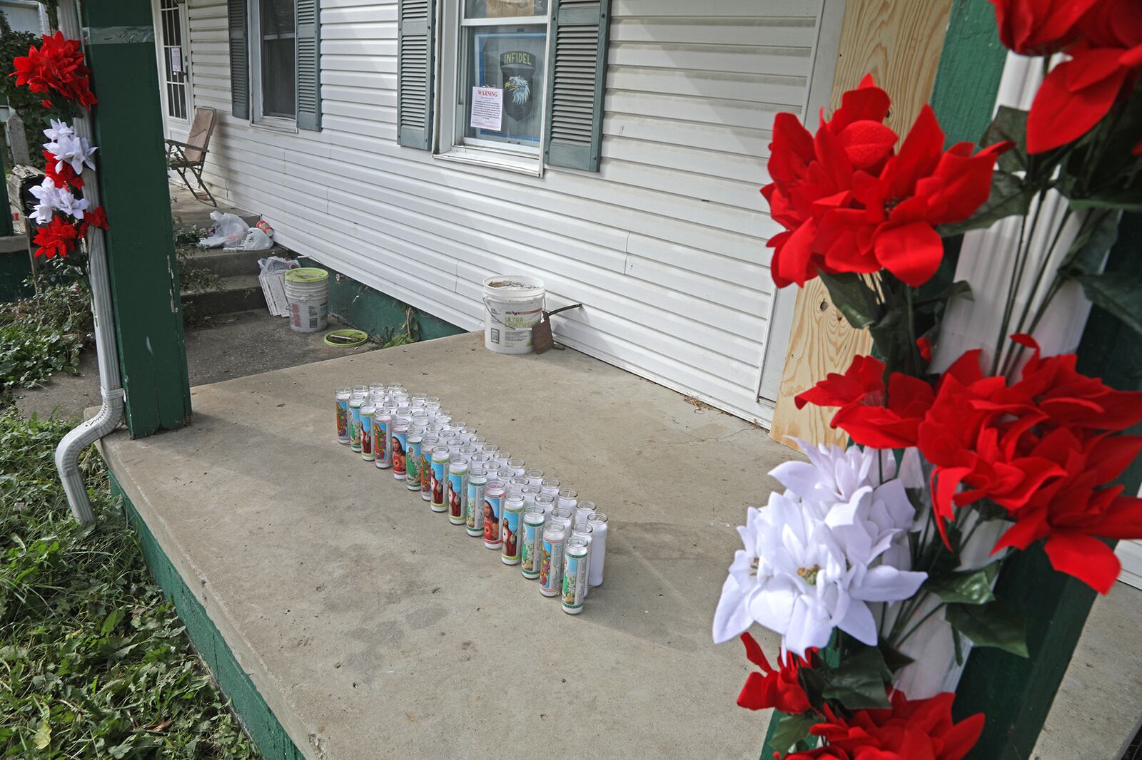 A memorial, made up of flowers and candles, has been made on the front porch at 41 North Douglas Avenue where the body of  Gloria Dickinson was discovered Wednesday. BILL LACKEY/STAFF