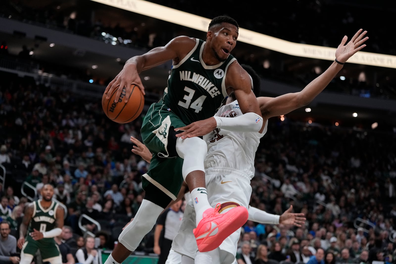 Milwaukee Bucks' Giannis Antetokounmpo passes to Damian Lillard in front of Cleveland Cavaliers' Jarrett Allen during the first half of an NBA basketball game Saturday, Nov. 2, 2024, in Milwaukee. (AP Photo/Morry Gash)