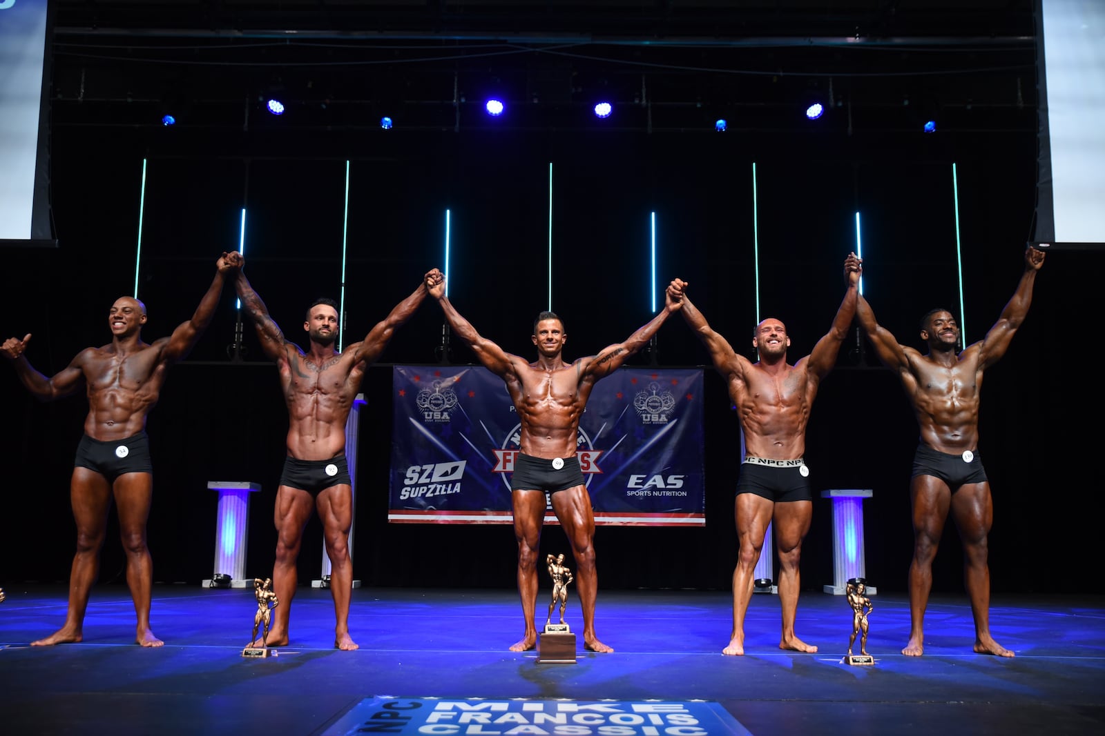 Eric Porter, center, is an amateur body builder when he is not running the camera for Gov. Mike DeWine's coronavirus press briefings.