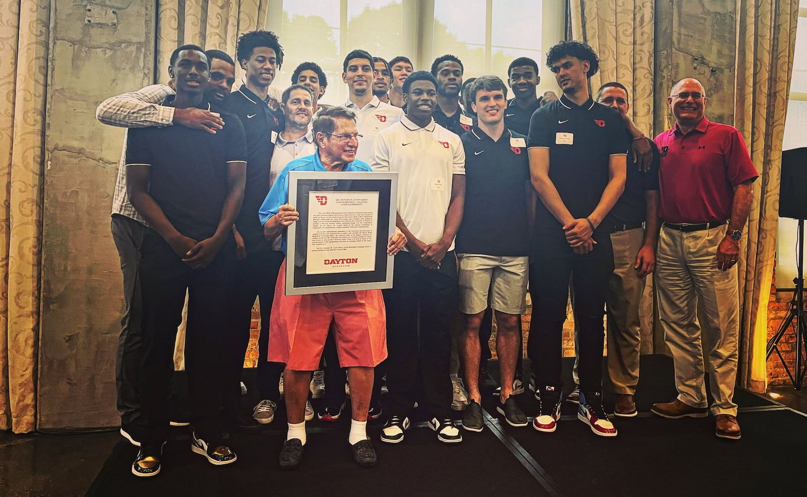 Dr. Stephen Levitt poses for a photo with the Dayton Flyers at an event celebrating his birthday and his gift to the program endowing the head men's basketball coaching position. David Jablonski/Staff