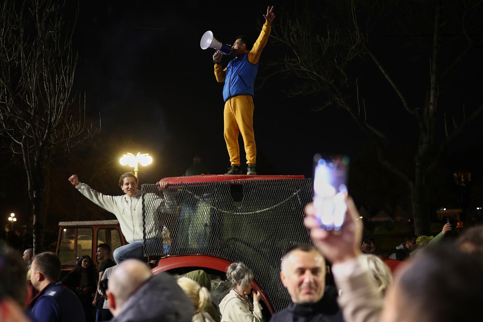 A man on a tractor talks to the people gathering to welcome students who have arrived ahead of a major rally this weekend in downtown Belgrade, Serbia, Friday, March 14, 2025. (AP Photo/Armin Durgut)