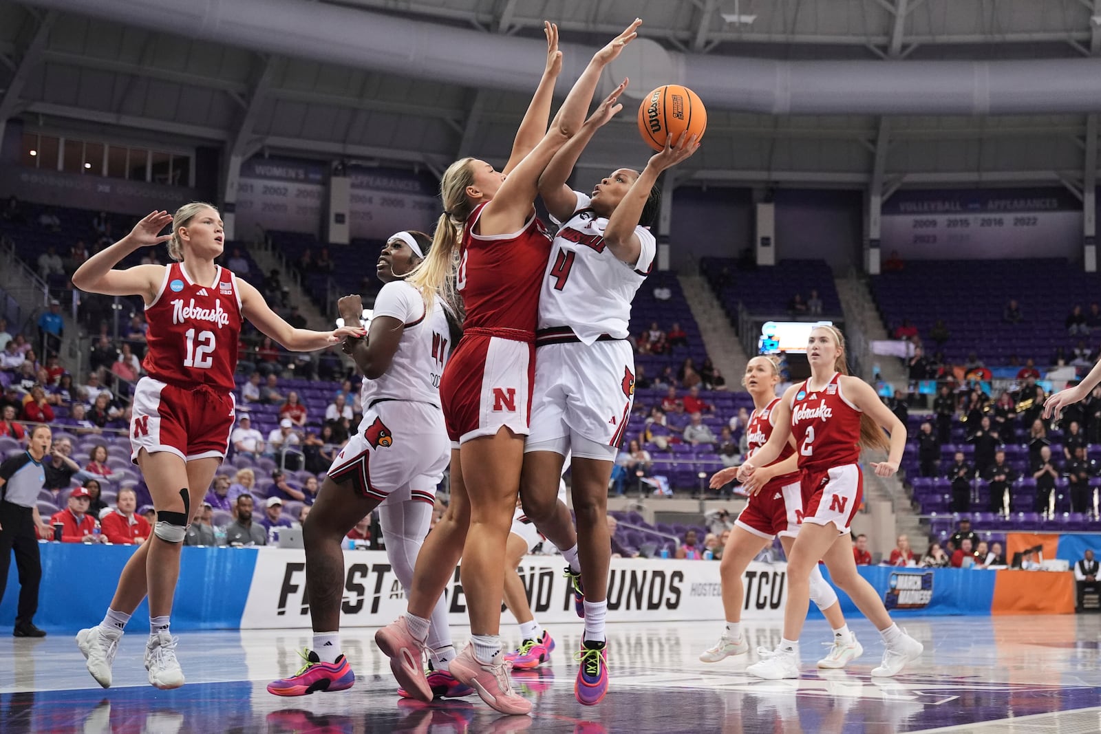 Louisville forward Mackenly Randolph (4) takes a shot as Nebraska's Alexis Markowski, left, defends in the first half in the first round of the NCAA college basketball tournament in Fort Worth, Texas, Friday, March 21, 2025. (AP Photo/Tony Gutierrez)