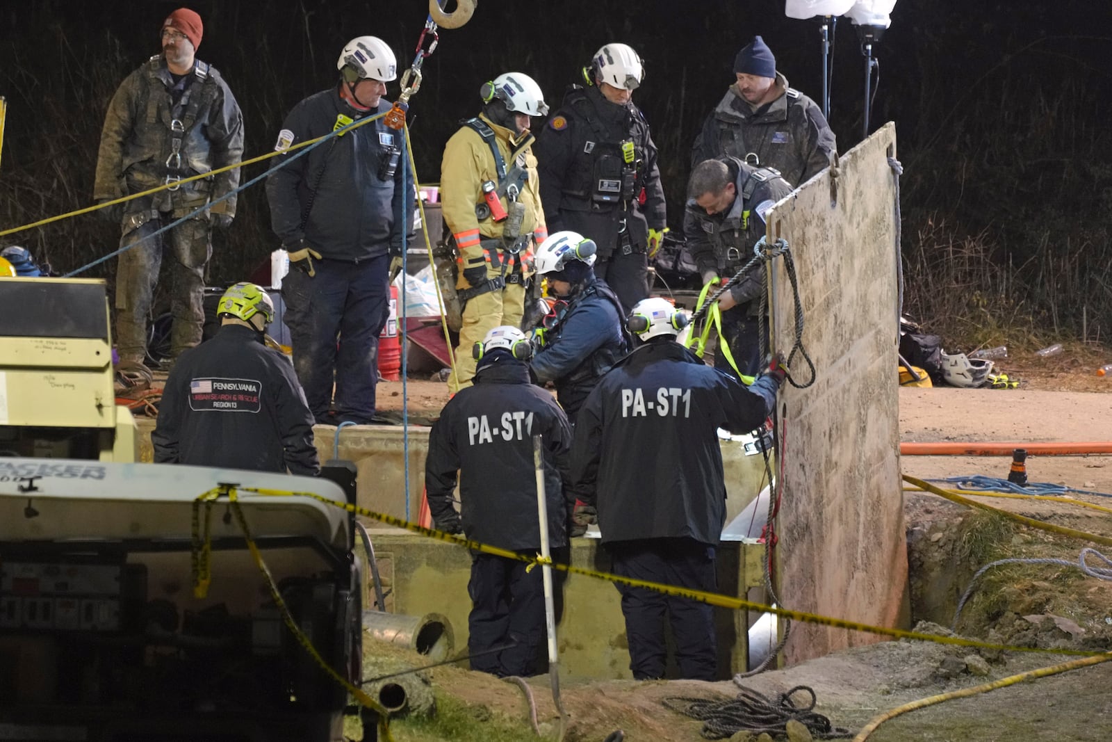 Rescue workers search through the night in a sinkhole for Elizabeth Pollard, who disappeared while looking for her cat, in Marguerite, Pa., Tuesday, Dec. 3, 2024. (AP Photo/Gene J. Puskar)