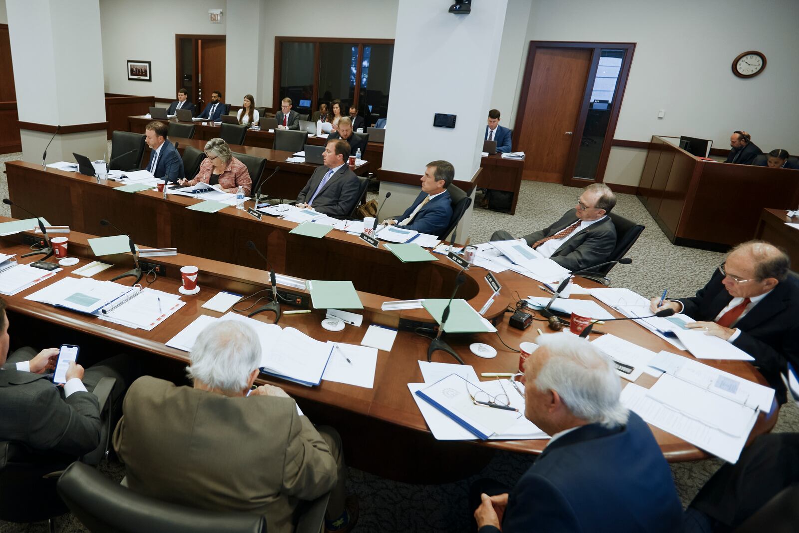 Members of the Mississippi Joint Legislative Budget Committee, sitting at a U-shaped table, meet at the Woolfolk state office building Sept. 26, 2024, in Jackson, Miss., with staff members sitting at a separate table behind them. (AP Photo/Justin Hardiman)