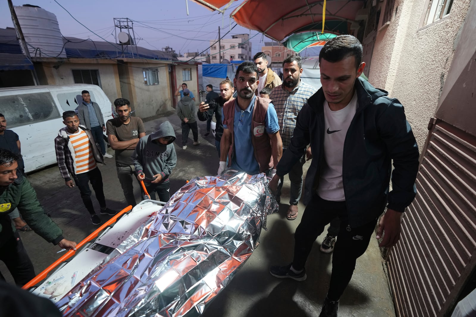 Palestinians carry a body of a person killed during an Israeli bombardment in Nuseirat, central Gaza, at a hospital morgue in Deir al-Balah, Gaza Strip, Wednesday, Nov. 20, 2024. (AP Photo/Abdel Kareem Hana)