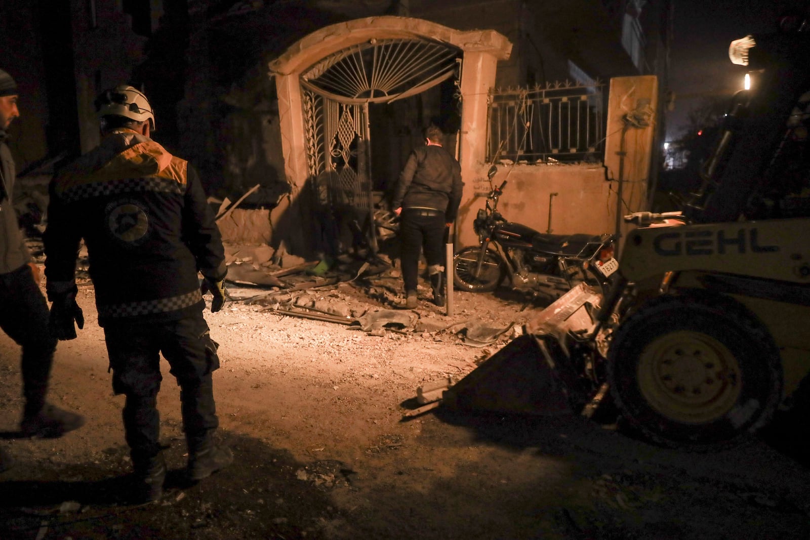 Residents inspect the site of an air strike in Idlib, Syria, Sunday Dec. 1, 2024. Government airstrikes in Idlib killed at least three civilians, including two children, and wounded 11 others, said the Syrian Civil Defense, known as the White Helmets, which operates in opposition-held areas. (AP Photo/Omar Albam)