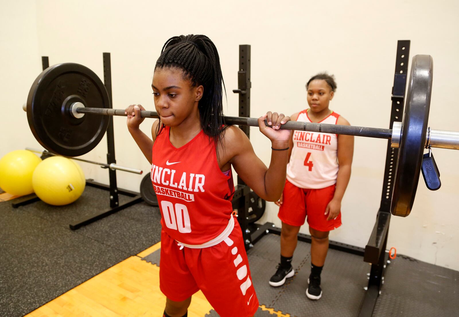 Laquelle Jacobs lifts weights as Kierre James spots her at Sinclair Community College's weight room. Both women play on the women's basketball team. Jacobs is from Toledo and James is from Lima. LISA POWELL / STAFF