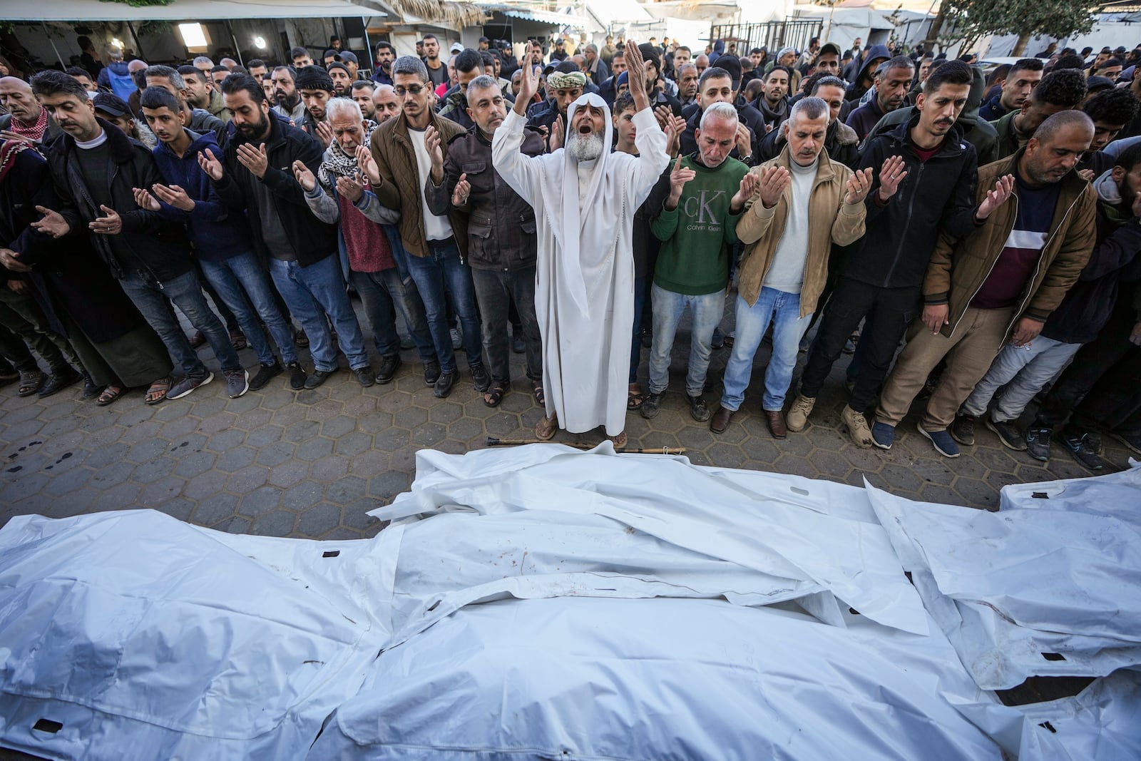 Palestinians pray over the bodies of the victims of an Israeli strike on a home late Saturday before the funeral outside the Al-Aqsa Martyrs Hospital in Deir al-Balah Sunday, Dec. 22, 2024. At least eight people were killed according to the hospital which received the bodies.(AP Photo/Abdel Kareem Hana)