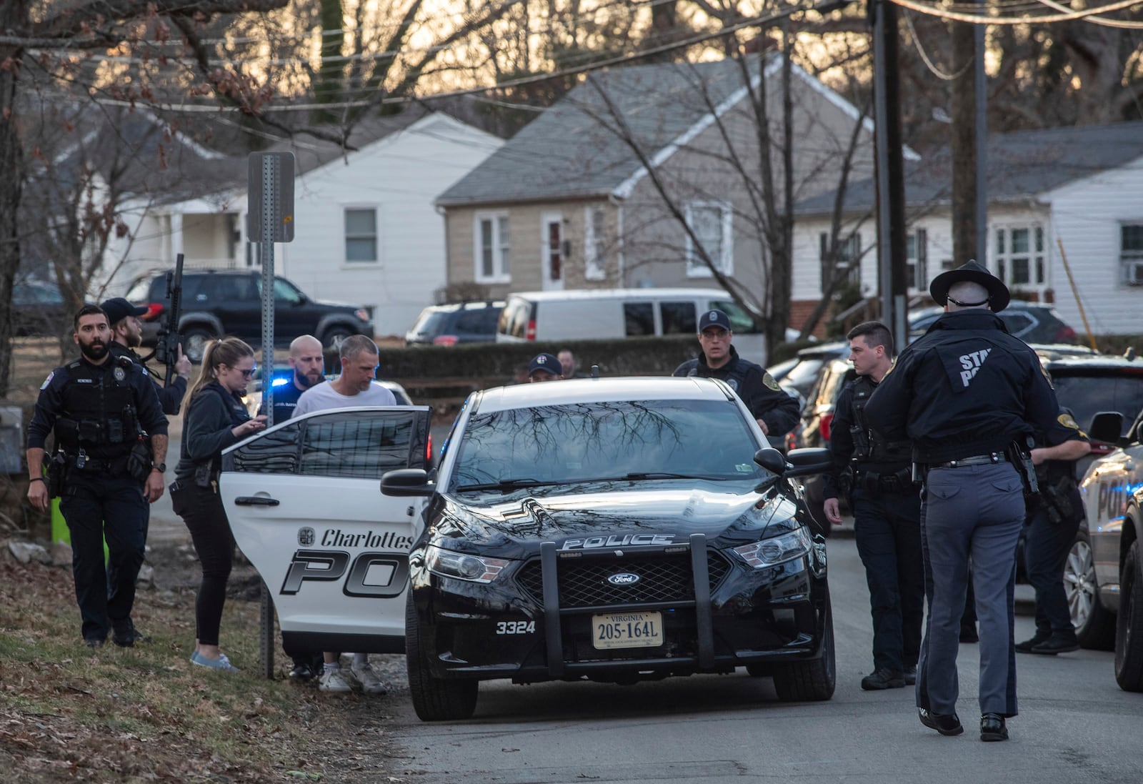 Charlottesville police guide the man suspected of a knife attack on University of Virginia Grounds into a police car, Thursday, Feb. 27, 2025, on Stribling Avenue on the border of the city's Jefferson Park Avenue and Fifeville neighborhoods. (Cal Cary/The Daily Progress via AP)