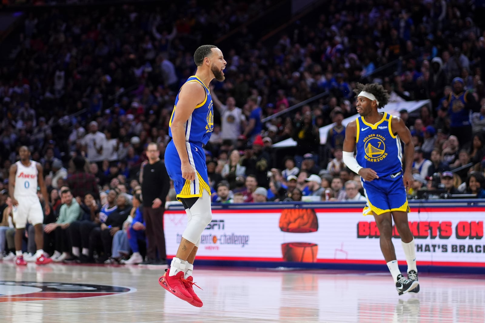 Golden State Warriors' Stephen Curry, center, reacts after a dunk during the second half of an NBA basketball game against the Philadelphia 76ers Saturday, March 1, 2025, in Philadelphia. (AP Photo/Matt Slocum)