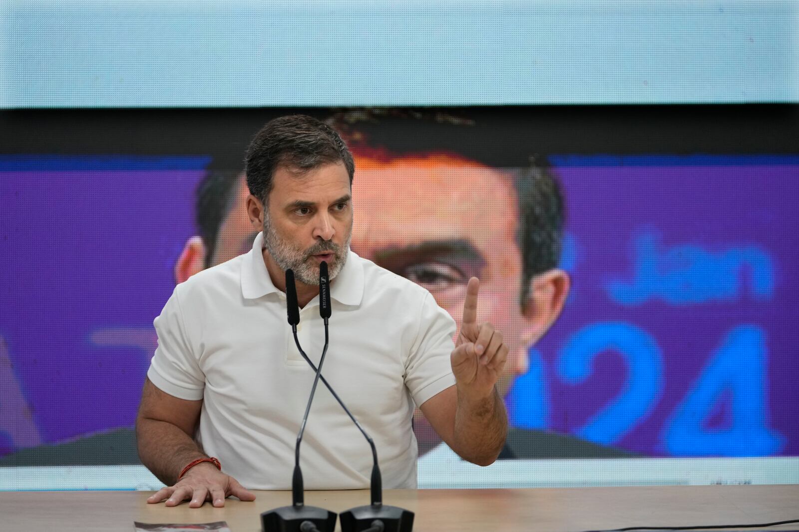 India's opposition Congress party leader Rahul Gandhi addresses the media on Indian businessman Gautam Adani, after Adani was indicted by U.S. prosecutors on charges he duped investors in a massive solar energy project in India, in New Delhi, India, Thursday, Nov. 21, 2024. Image behind shows Adani. (AP Photo/Manish Swarup)