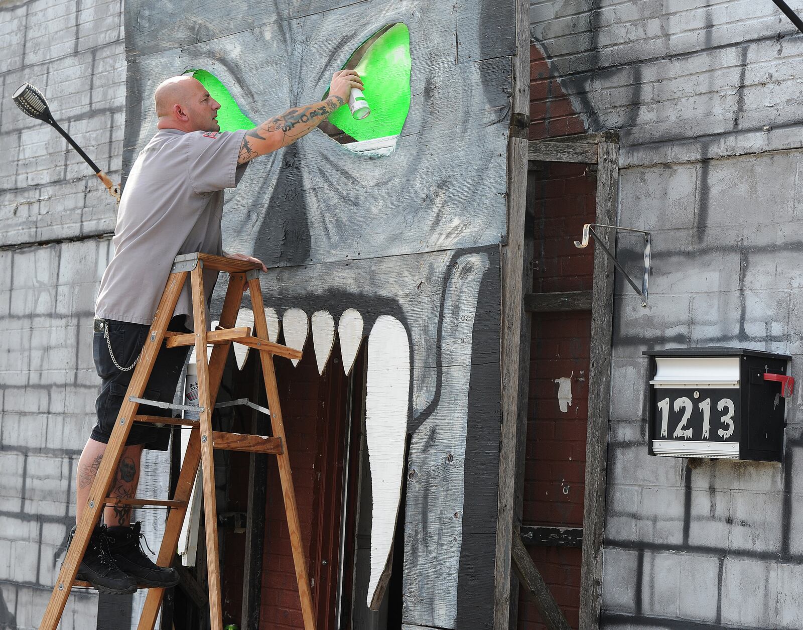 Jason Byrd, paints the eyes on the skull on the front of the Riverside Jaycees, Haunted House, located at 1213 Old Harshman Road. MARSHALL GORBY\STAFF