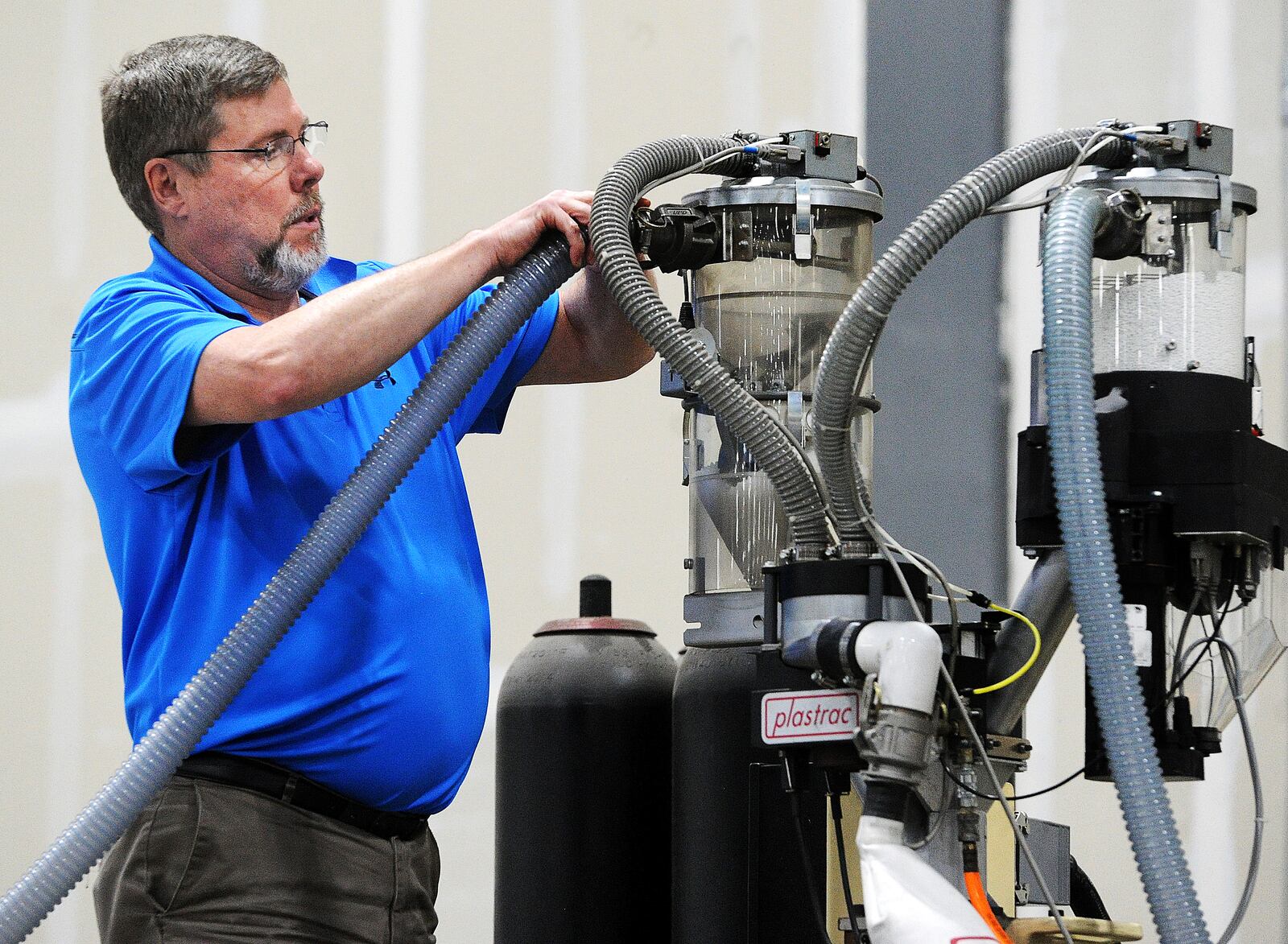 Brian O'Leary owner of on Innovative Plastic Molders, helps to repair one of his machines. The company is celebrating its 20th anniversary being open. MARSHALL GORBY\STAFF