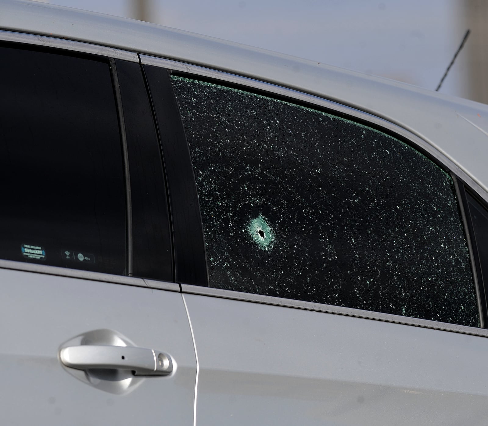 Two of the six bullet holes in a silver SUV after a shooting at U.S. 35 West  and I-75 Monday, November 14, 2022. MARSHALL GORBY \STAFF