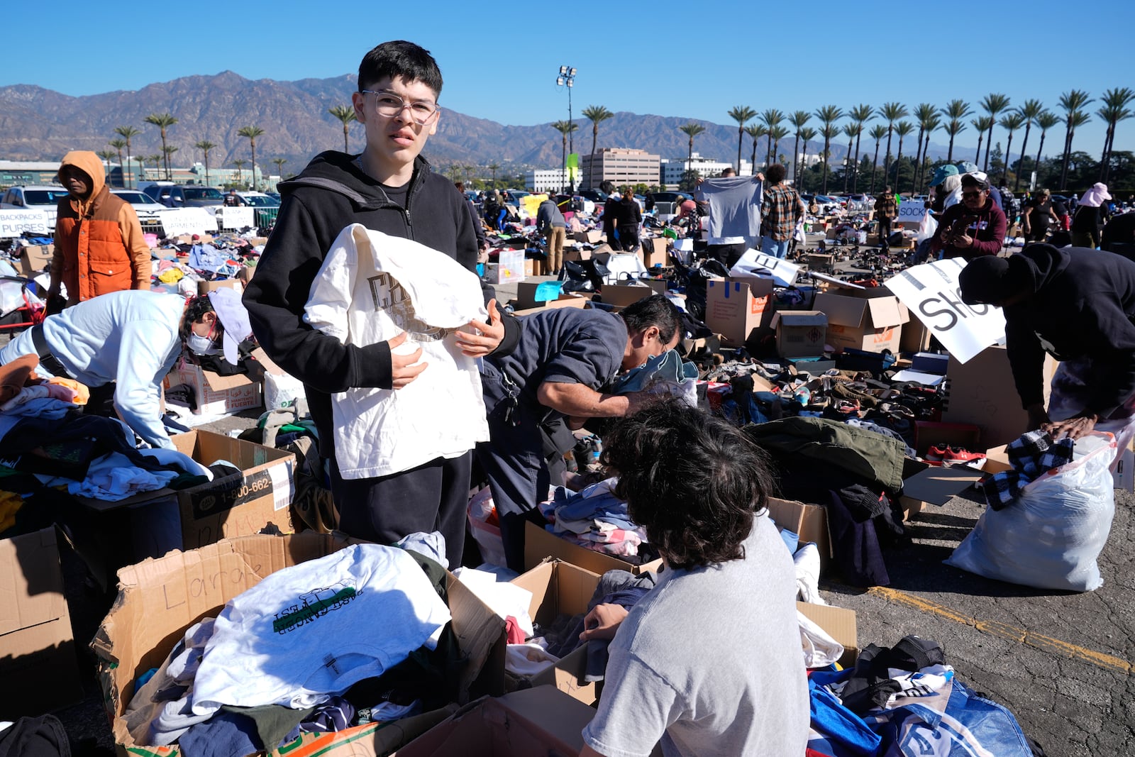 Ivan Benavidez, left, and his brother Isaac, who lost their home in the Altadena fire, look for clothes at a donation center at Santa Anita Park in Arcadia, Calif., Wednesday, Jan. 15, 2025. (AP Photo/Richard Vogel)