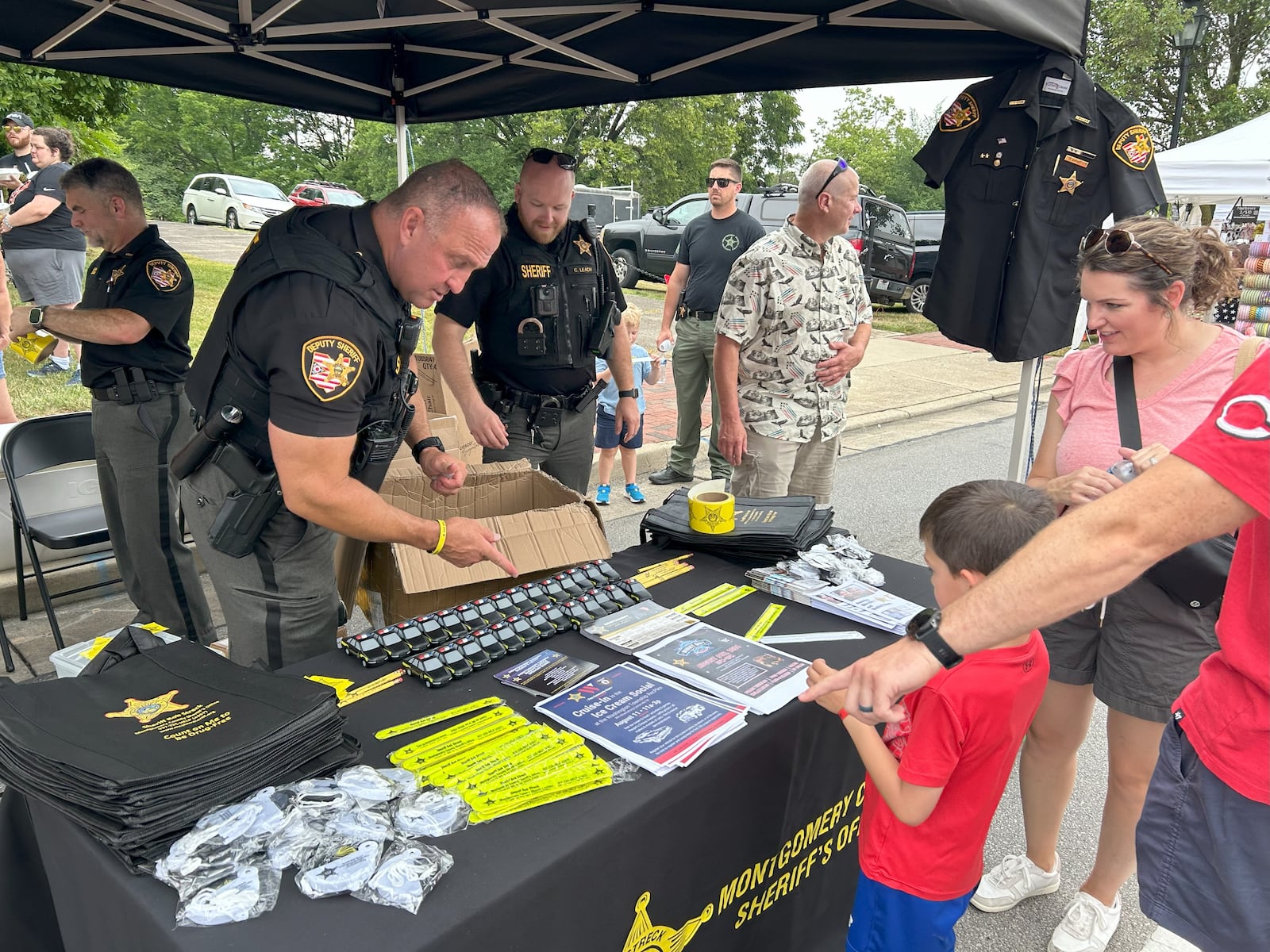 A boy selects a toy from the Montgomery County Sheriff's office booth at the Centerville-Washington Township Americana Festival on Thursday, July 4, 2024 in Centerville. LYNN HULSEY/STAFF