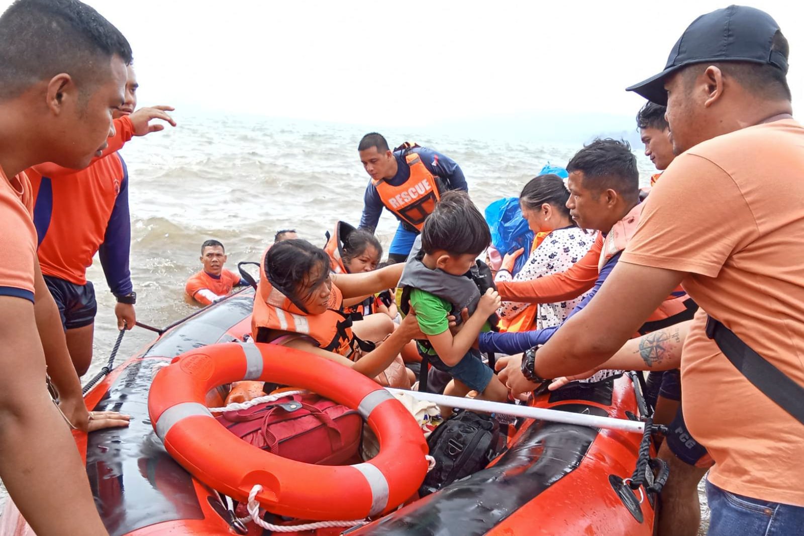 In this photo provided by the Philippine Coast Guard, residents alight a rubber boat after being ferried to safer grounds in Batangas province, Philippines on Friday, Oct. 25, 2024. (Philippine Coast Guard via AP)