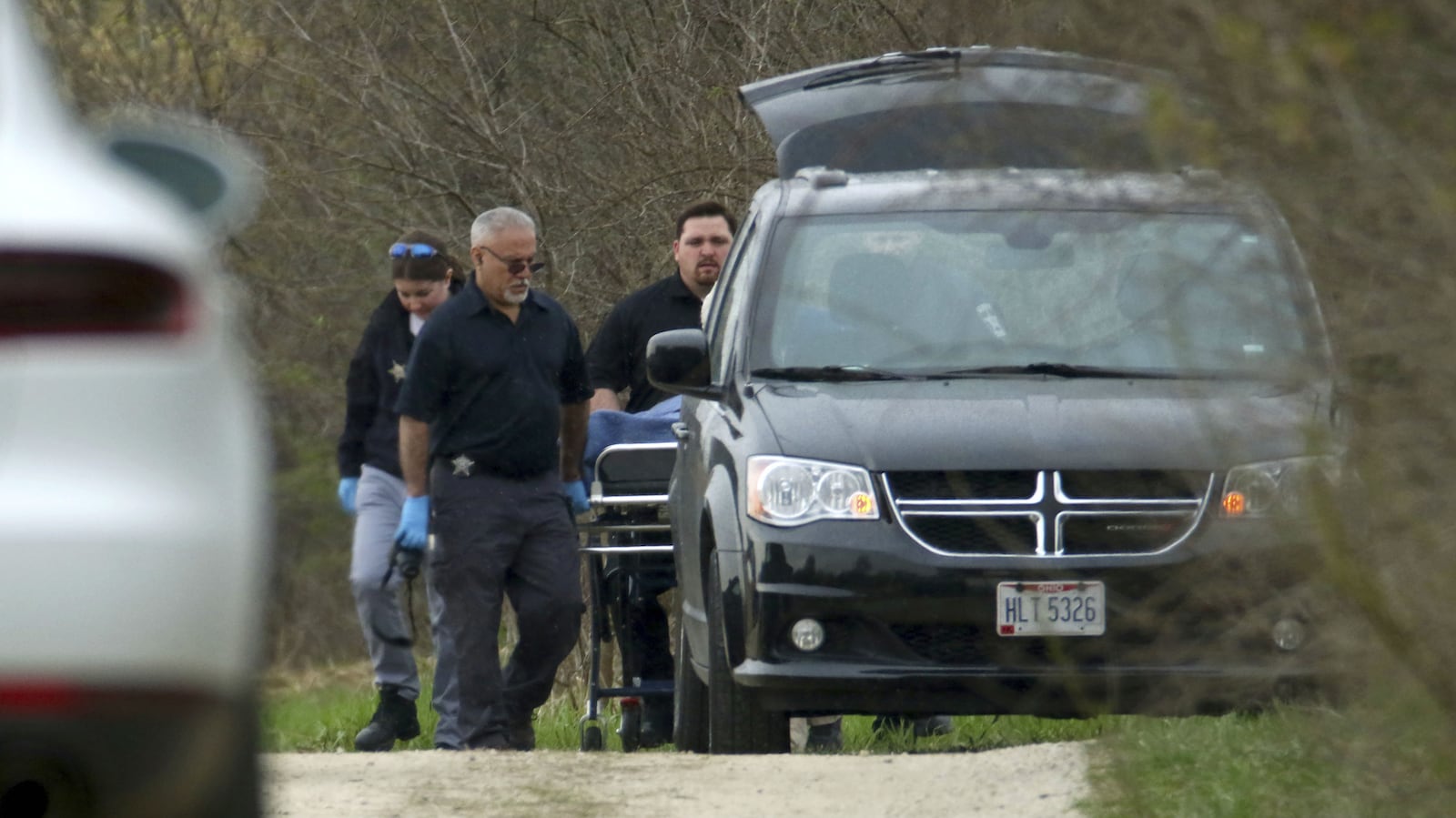 McHenry County Coroner's Office investigators load the body of 5-year-old Andrew "AJ" Freund Jr. into a minivan in the wooded area in which he was found Wednesday, April 24, 2019, near Woodstock, Ill. The boy's parents, JoAnn Cunningham, 36, and Andrew Freund Sr., 60, face multiple charges, including five counts of first-degree murder, in the boy's death. AJ was reported missing from the family's Crystal Lake home Thursday, April 18, 2019. His body was found wrapped in plastic and buried in a shallow grave.