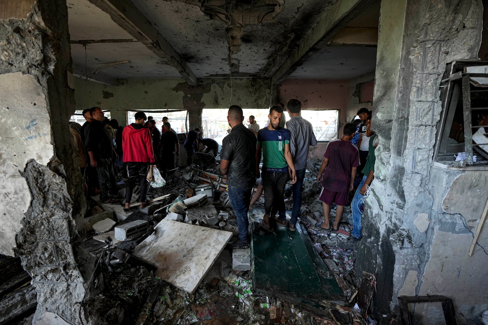 Palestinians search for the bodies of their relatives killed in an Israeli bombardment of a school in Deir al-Balah, central Gaza Strip, Thursday, Oct. 10, 2024. (AP Photo/Abdel Kareem Hana)