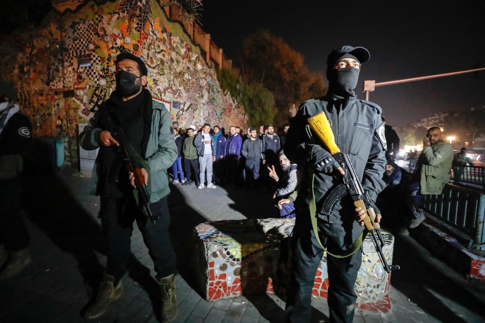 Security forces of the new Syrian government secure the area around group of Alawite protesters in the Mazzeh district in Damascus Wednesday Dec. 25, 2024. The minority Alawite community is an offshoot of Shiite Islam that form President Bashar Assad belongs to. (AP Photo/Omar Sanadiki)